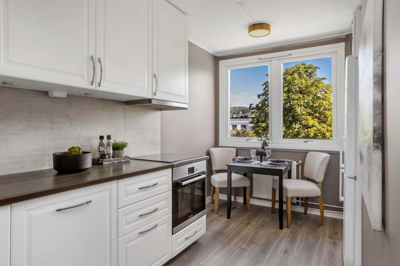 Kjøkkenet har plass til egen spisegruppe med fin utsikt over borettslagets grønne arealer. Her kan man nyte morgensolen når det passer seg Galleribilde