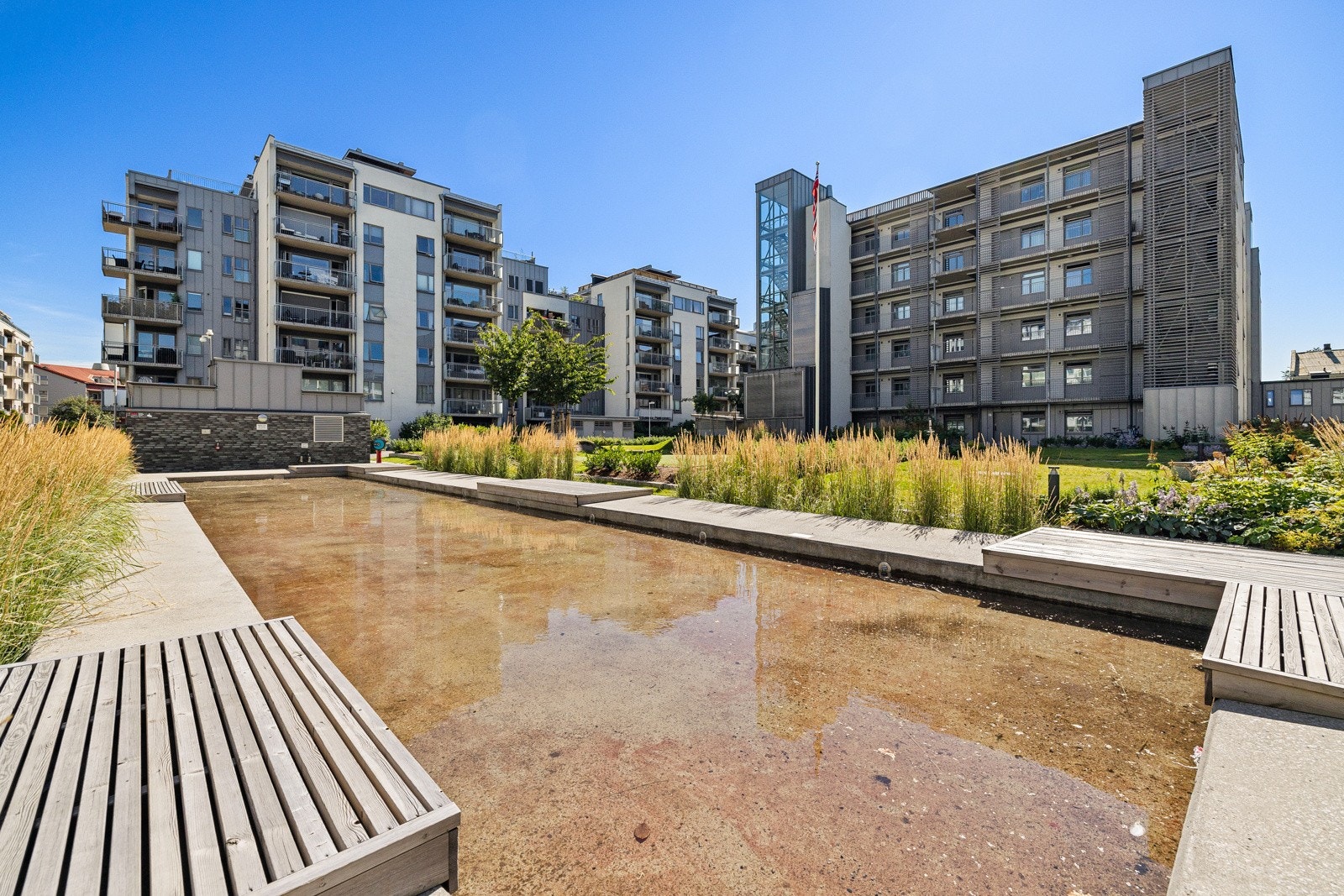 Gårdsrommet har blant annet vannspeil, kunstgress, store grøntarealer, asfalterte internveier og variert beplantning. Galleribilde