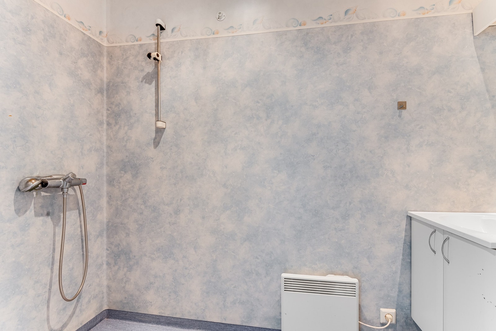 Eldre bad med gulvmontert wc, servant og dusjgarnityr. Galleribilde