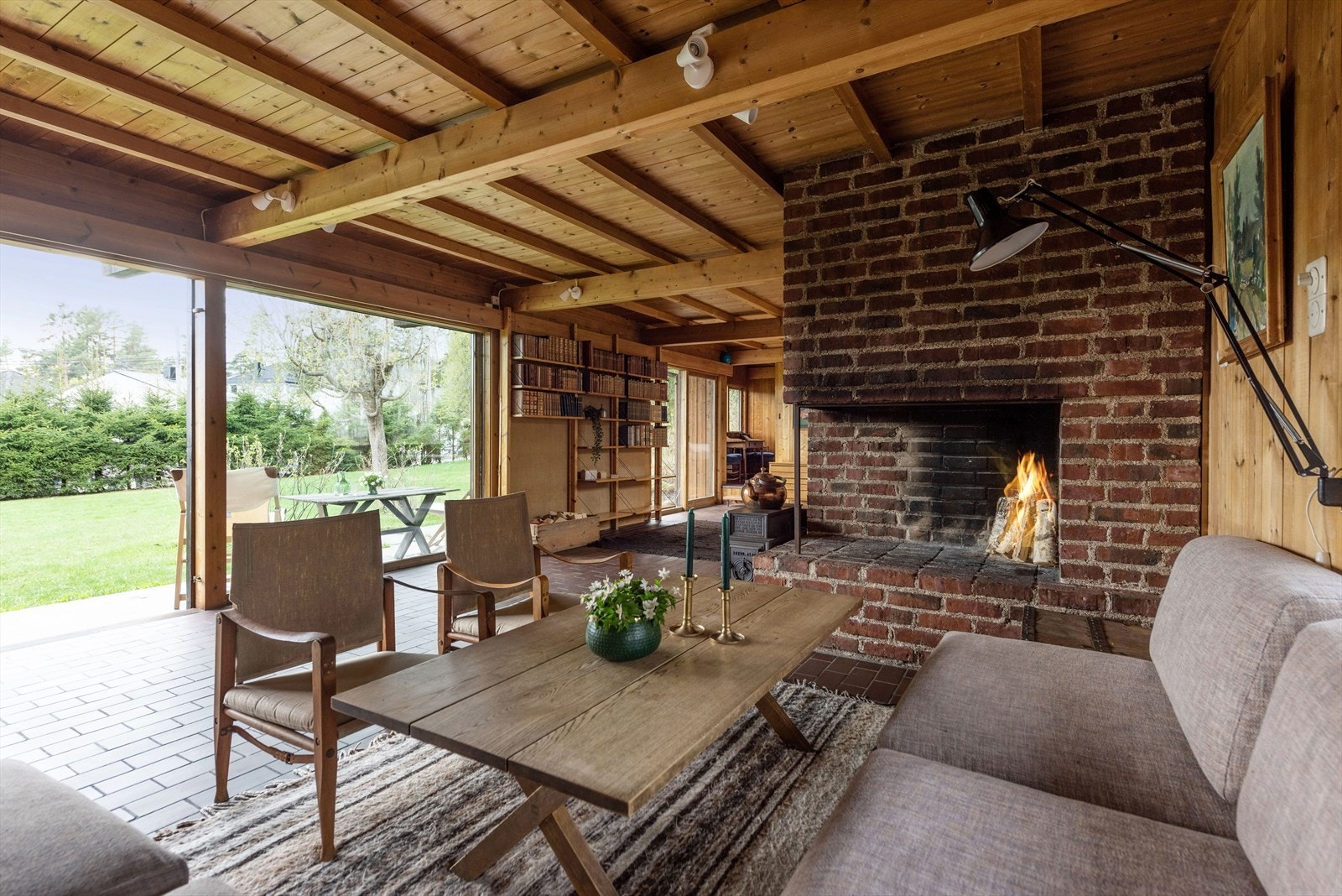 De store glassflatene kan lukkes med skyveskjermer skjult bak bokhyllen. Galleribilde