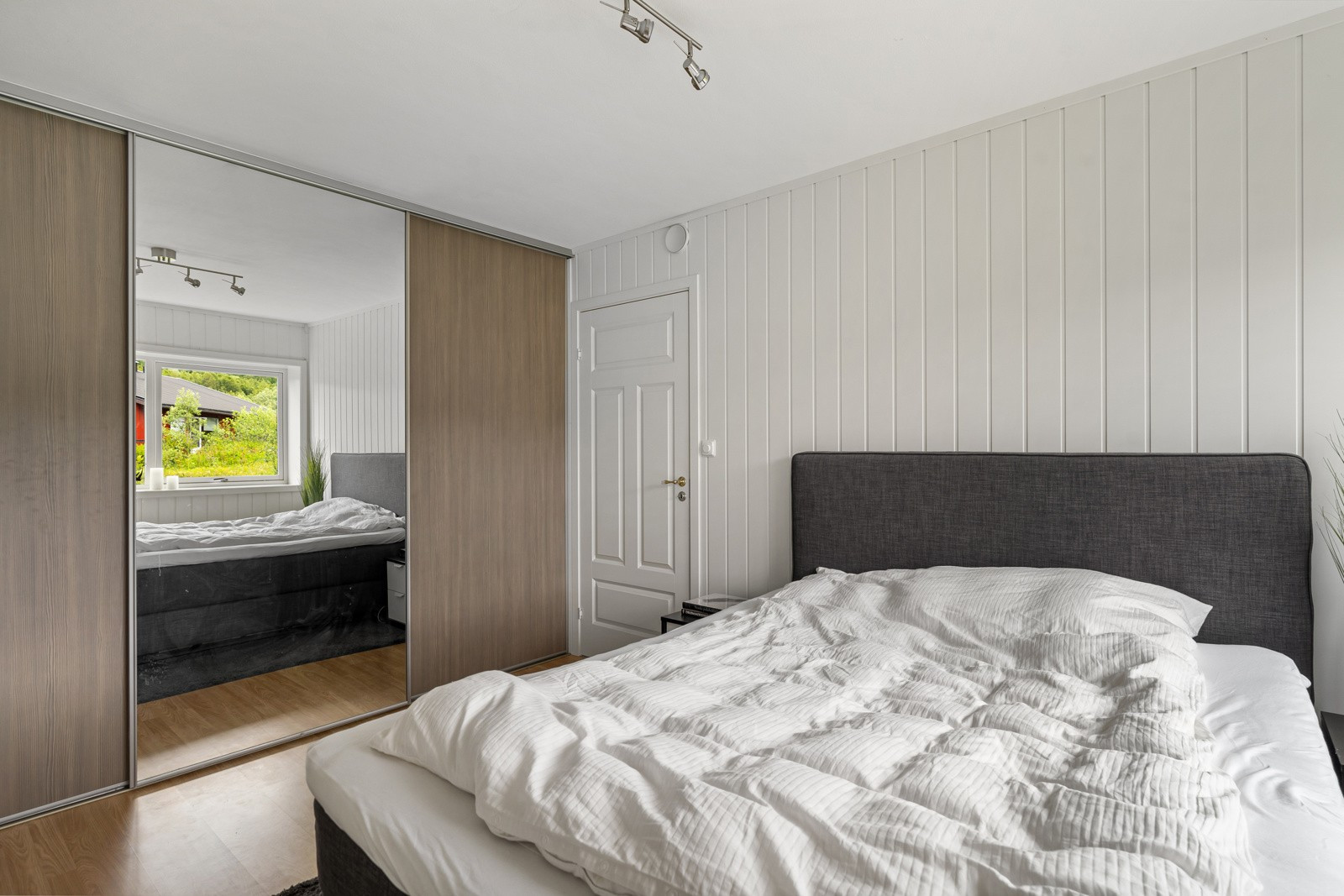 På soverommet er det en stor skyvedørsgarderobe som sikrer rikelig med oppbevaringsplass for klær.