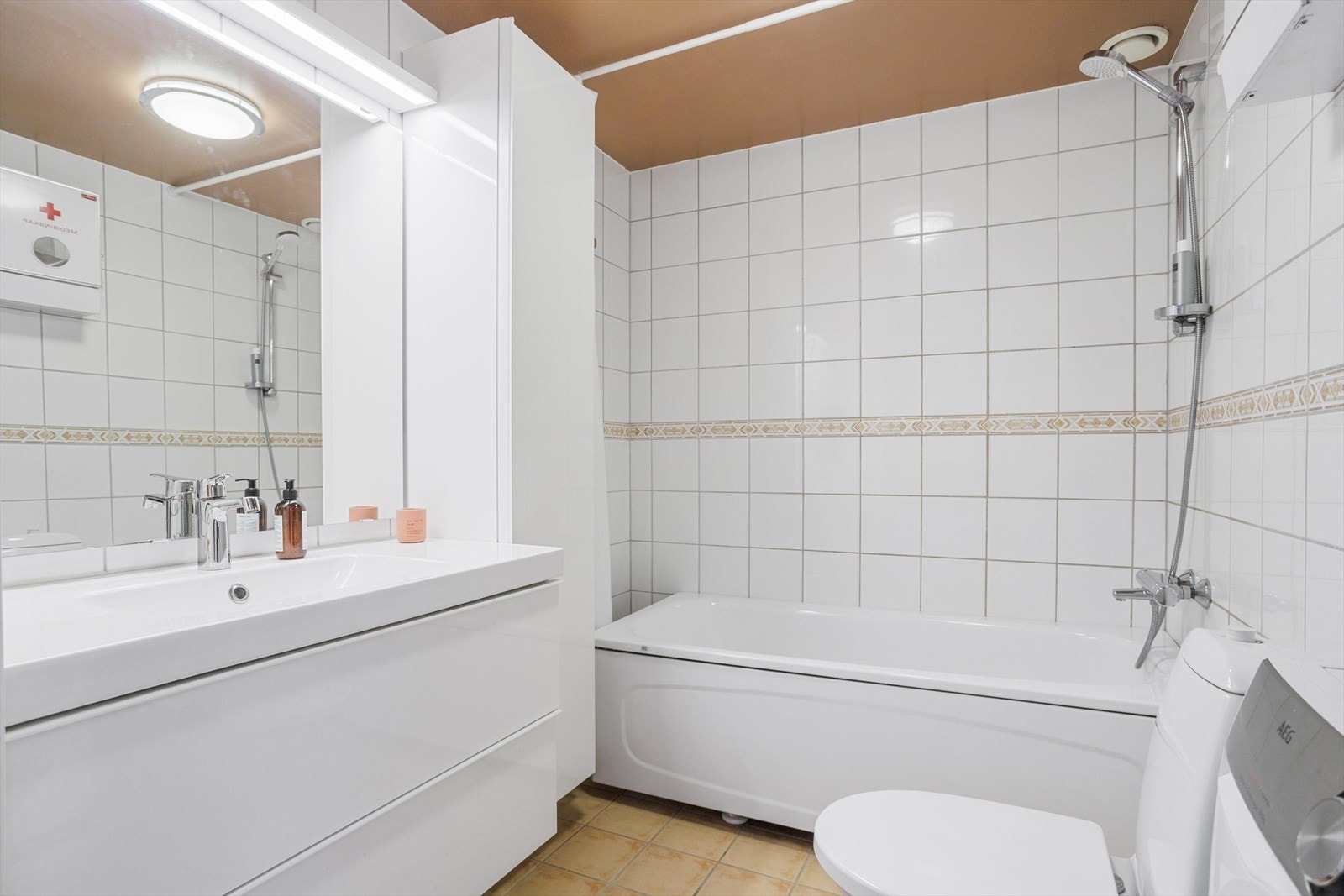 Det flislagte badet er fra byggeperioden med varmekabler i gulv og opplegg for vaskemaskin, og oppgradert med ny servant, underskap og høyskap i 2019/20. Galleribilde