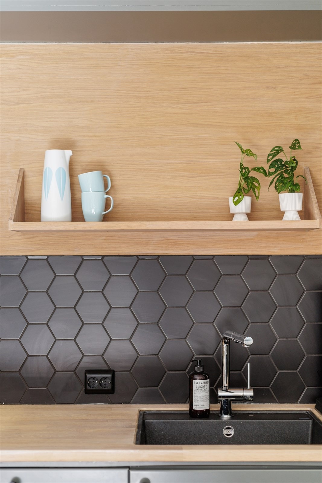 Innredningen består av matte fronter, mattsorte hexagonfliser over benkeskap, benkeplater i heltre og stein, underlimt oppvaskkum, samt en ventilator. Galleribilde