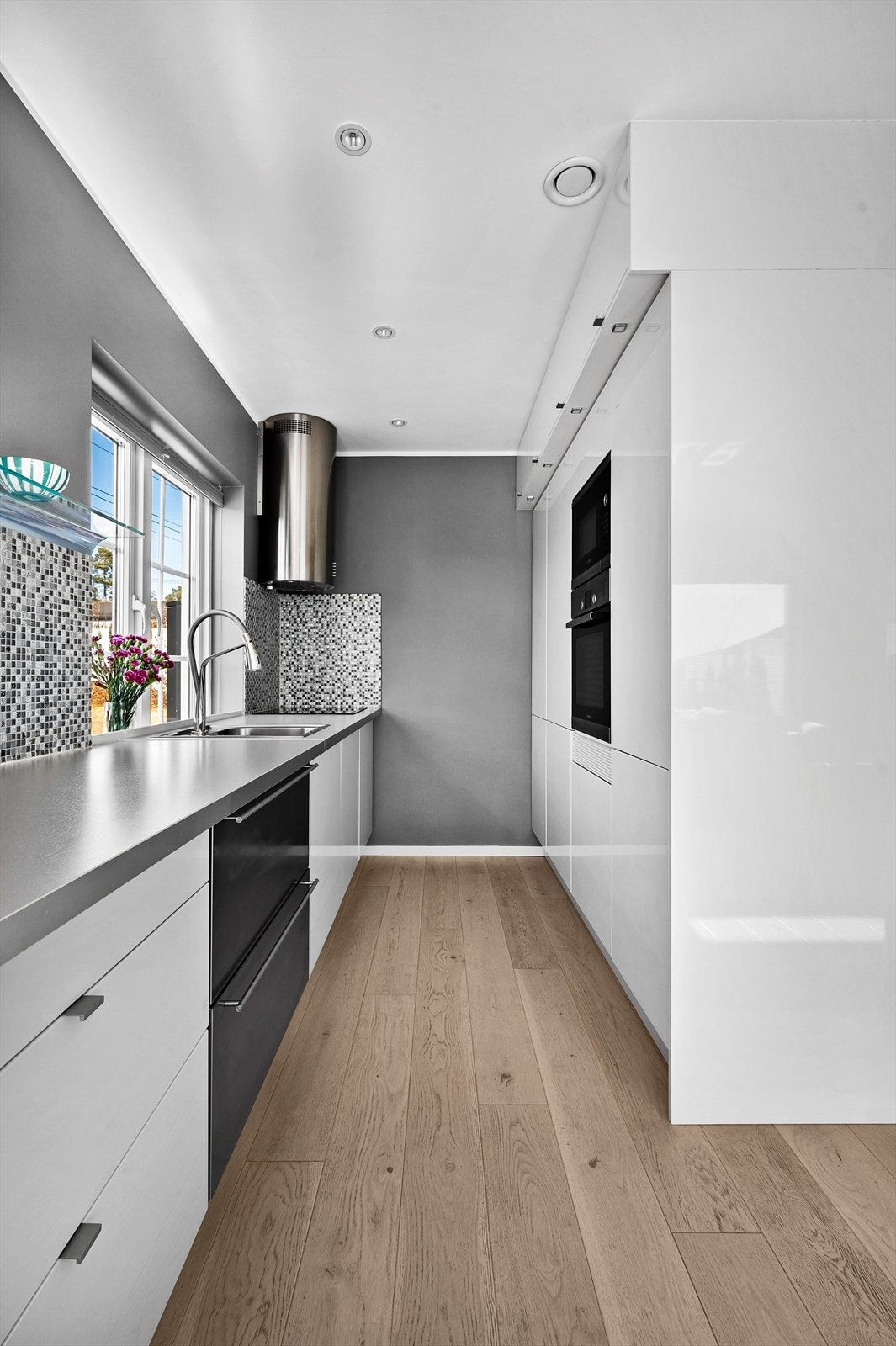 Innredningen består av skuffer og skap med glatte fronter. Benkeplate av laminat med flisfelt over. Integrerte hvitevarer som veggovn, micro, platetopp, kjøleboks og vinskap medfølger. Galleribilde