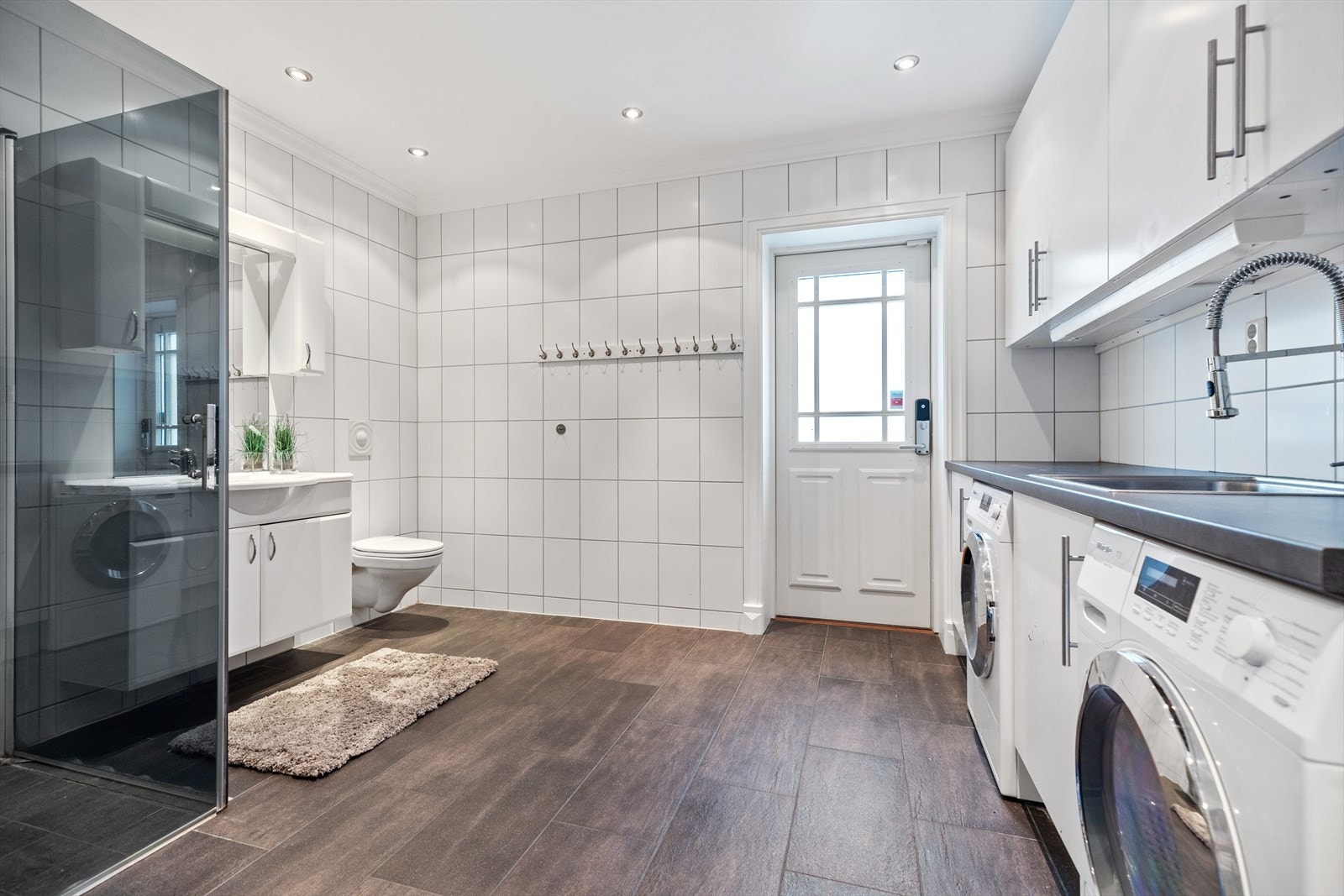 Stort og funksjonelt vaskerom med god plass til dusj, toalett mm. Det er i tillegg praktisk utgang til gårdsplassen. Galleribilde