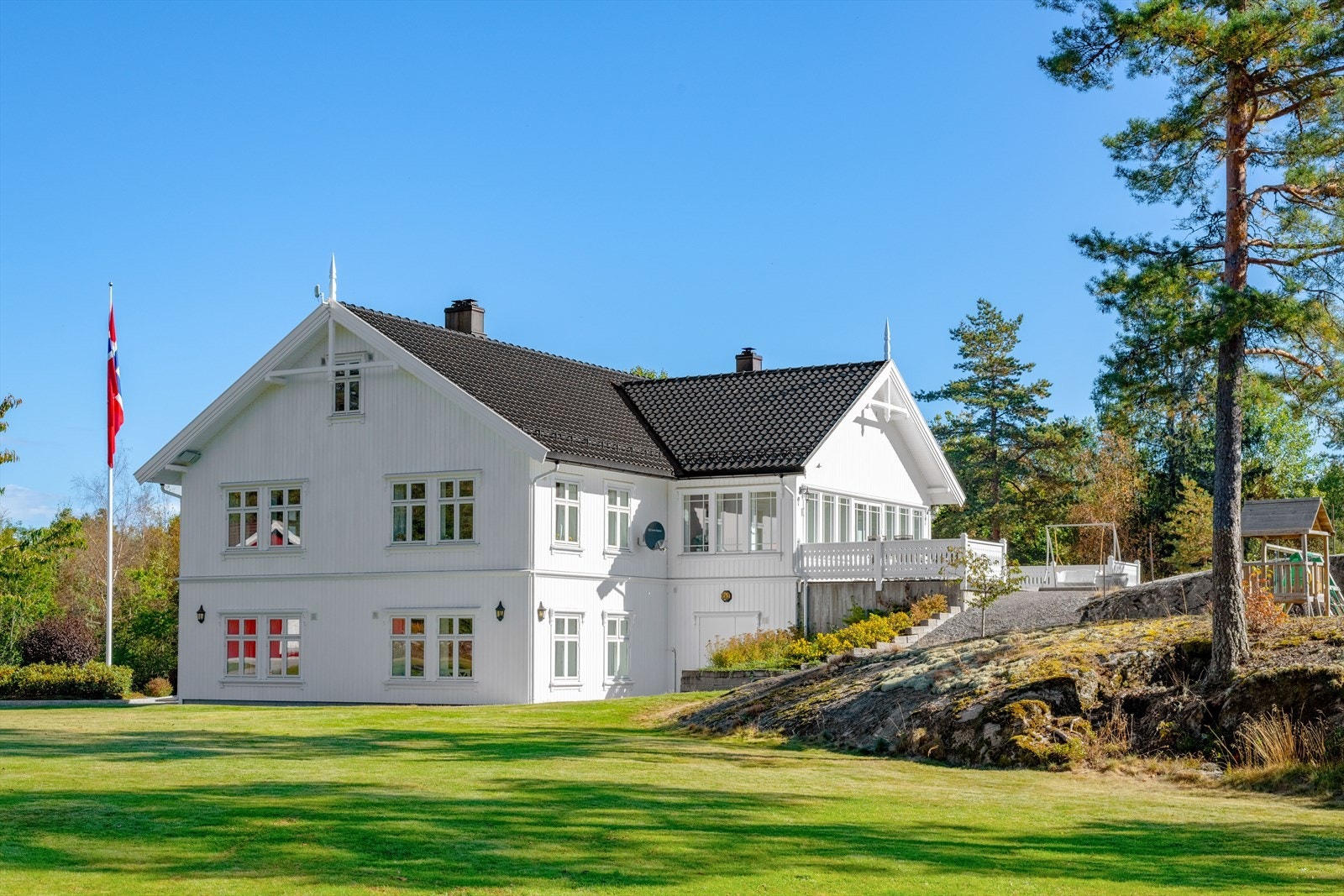 Tomten er vesentlig opparbeidet i senere tid, med stor gressplen, diverse beplantning, stor flaggstang og belegningsstein rundt huset Galleribilde