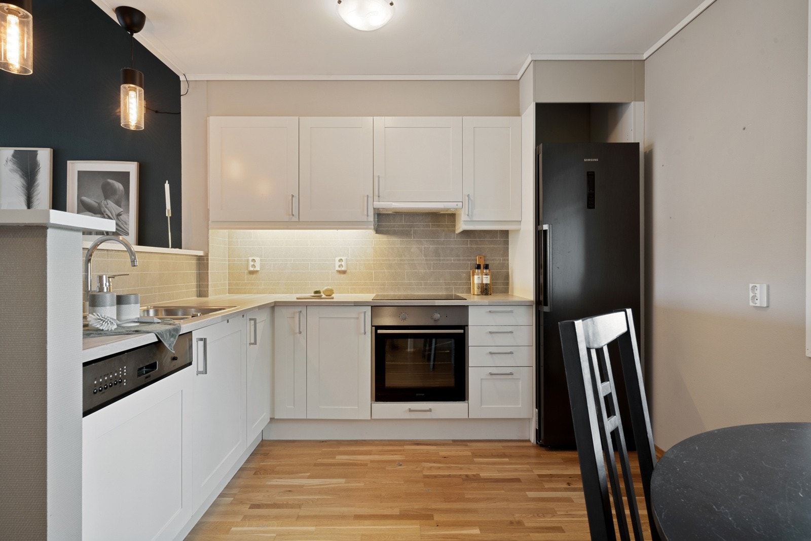 Stilrent hjørnekjøkken i praktisk utforming for ekstra god skap- og benkeplass Galleribilde