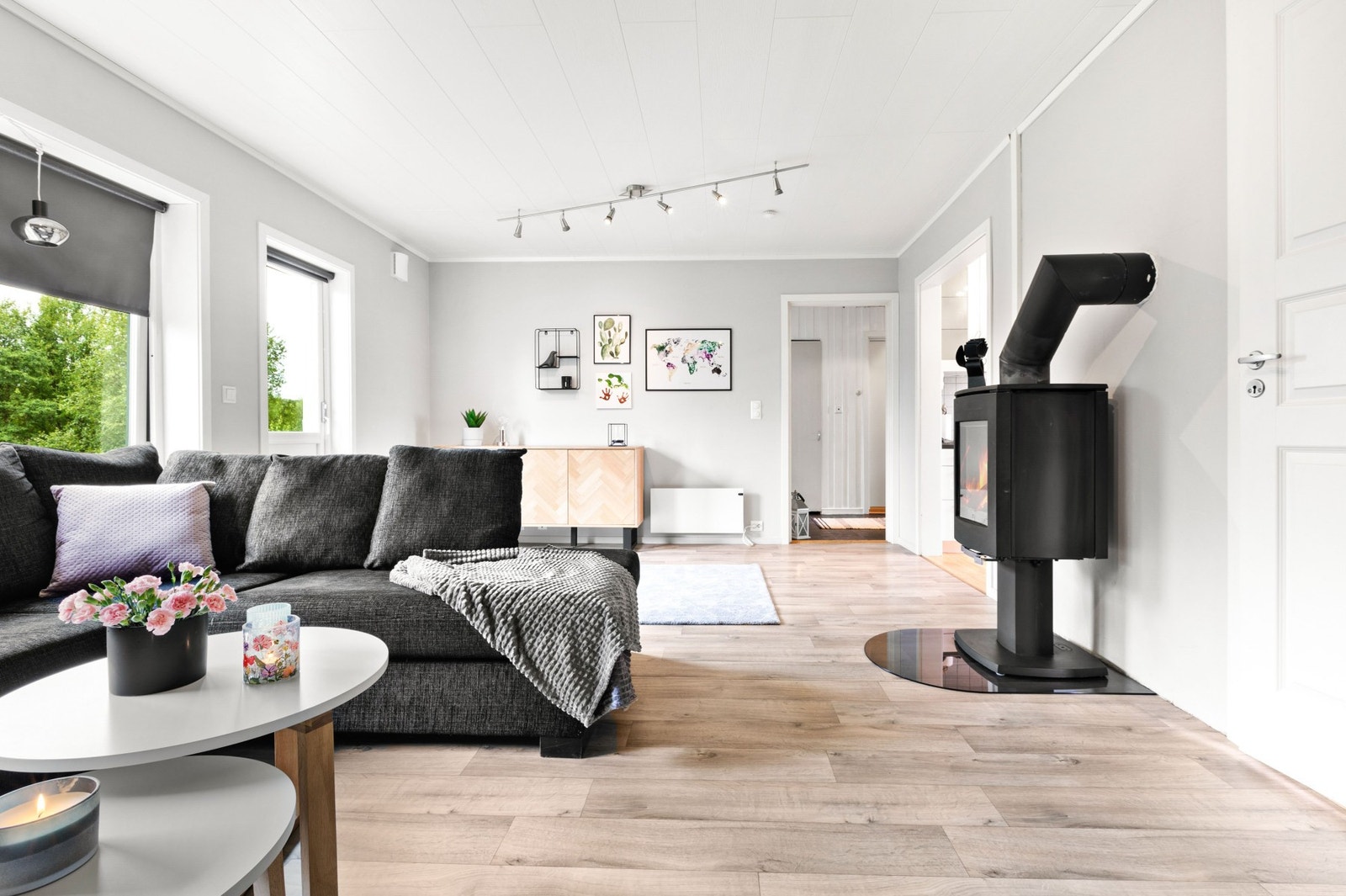 Leiligheten har en lys og luftig stue med vedovn og utgang til terrasse Galleribilde