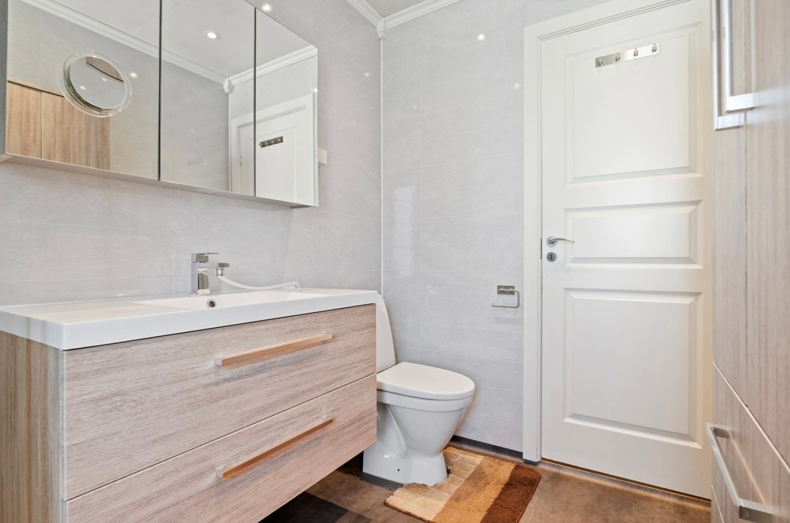 Badet er innredet med klosett, moderne innredning og dusjnisje med svingbare dører Galleribilde