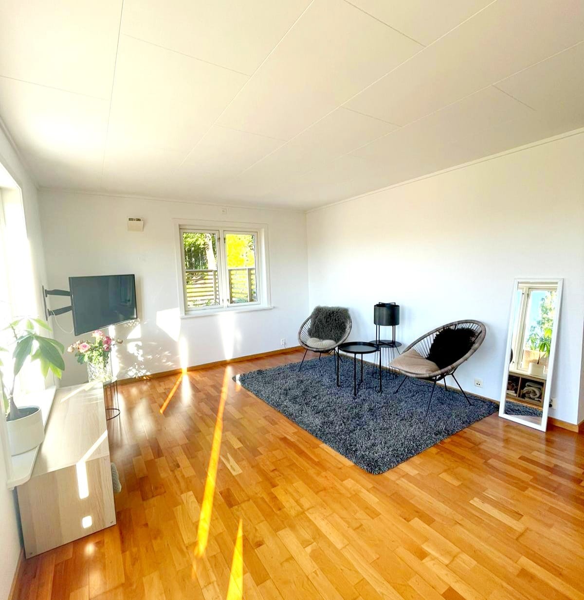 Åpen stue og kjøkkenløsning med tre store vinduer som gir godt lys Galleribilde