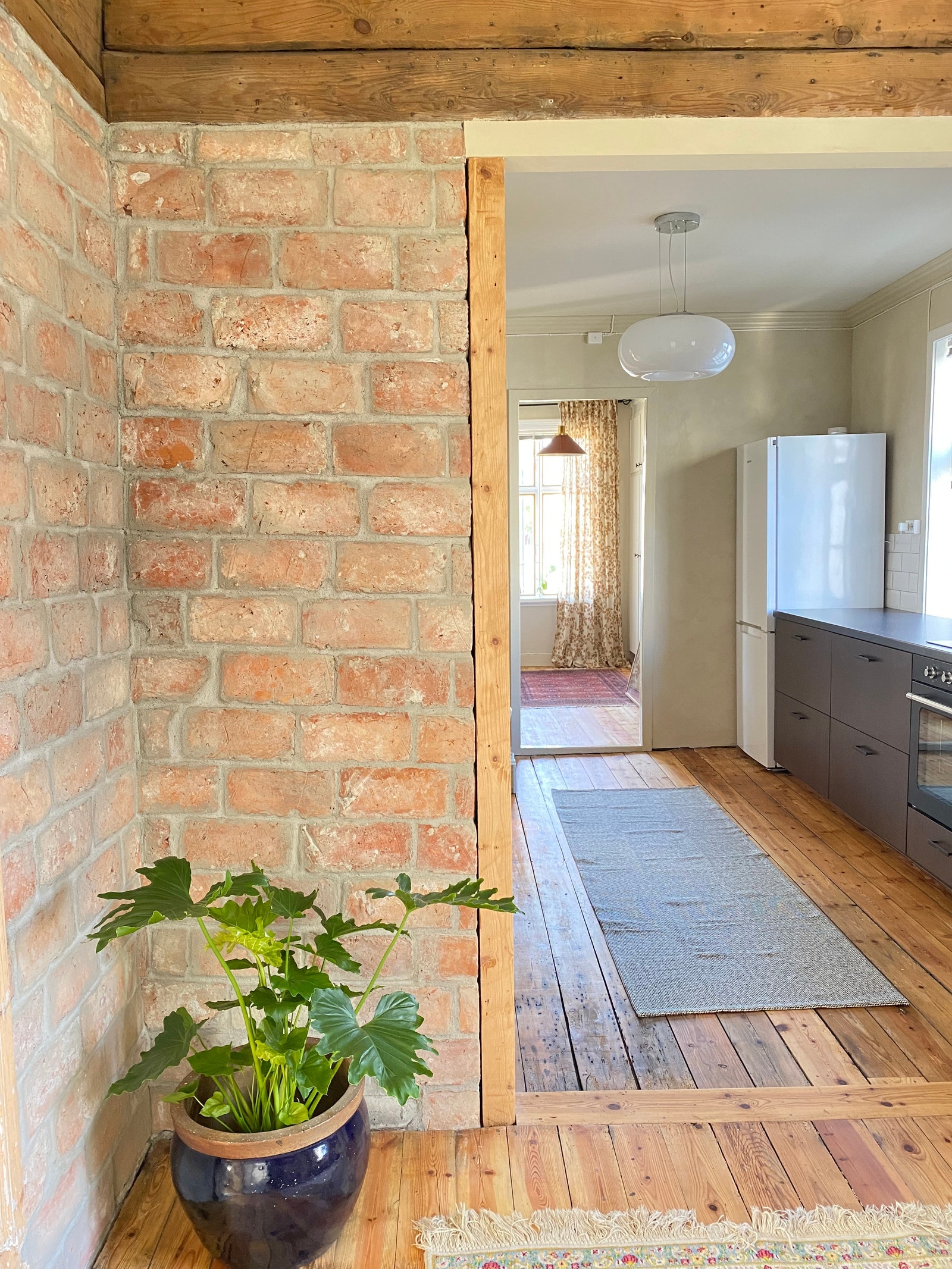 Lys og åpen løsning – utsikt fra stue til kjøkken og videre til 2. soverom. Originale gulv vakkert restaurert. Galleribilde