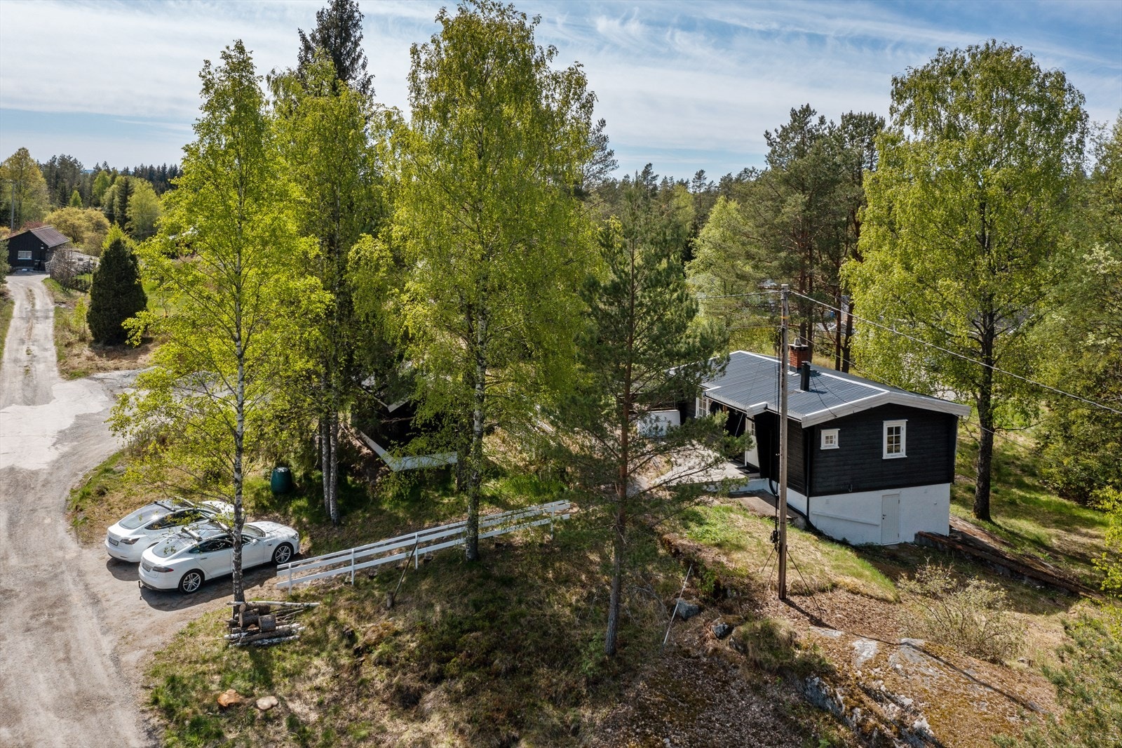 Noe plenarealer, og gruslagt gårdsplass med biloppstillingsplasser. Galleribilde