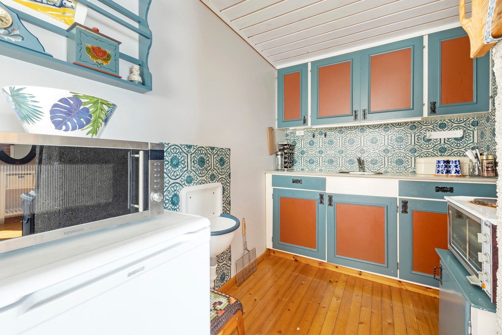 Malt kjøkkeninnredning med profilerte fronter, takhøye overskap og benkeplate i laminat Galleribilde