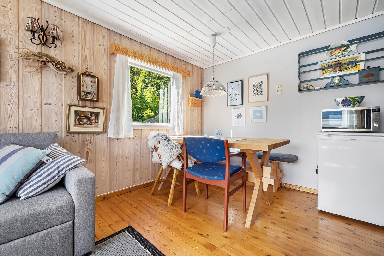 Stuen har åpen løsning mot spiseplass og kjøkken Galleribilde