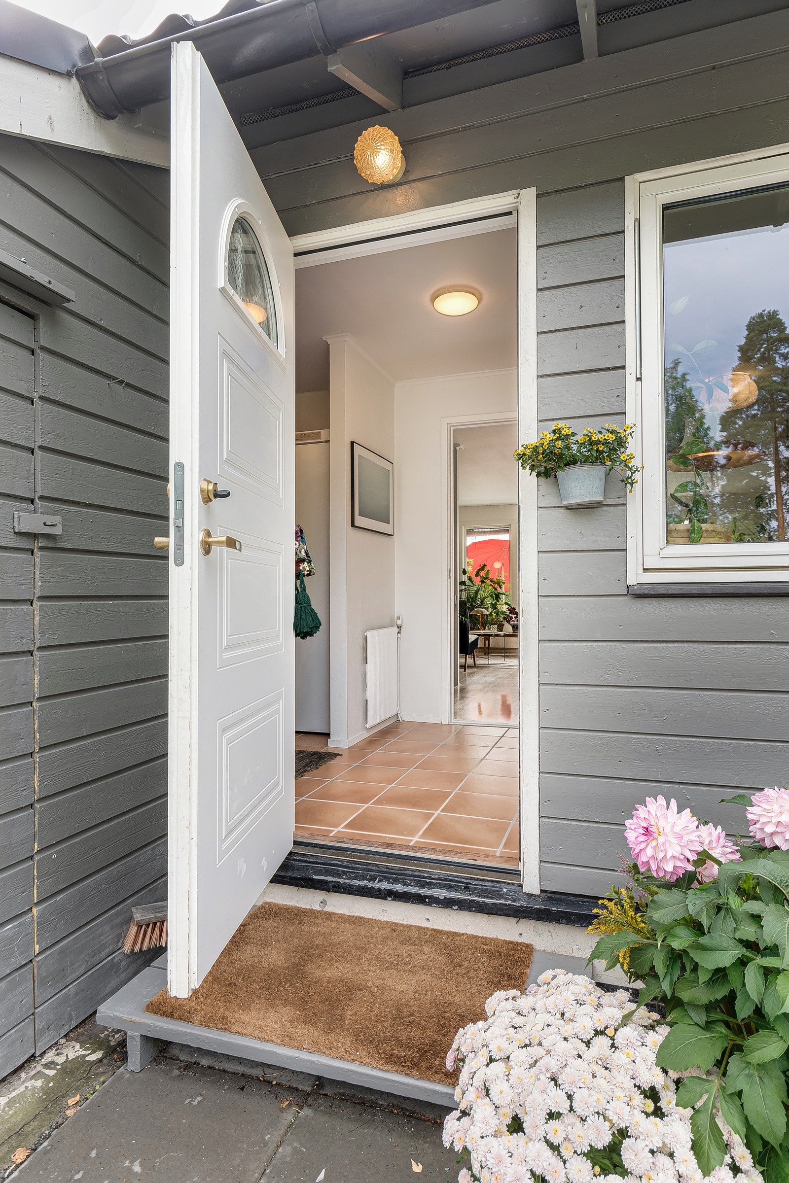 Åpner du døren møtes du av et åpent, lyst og flislagt inngangsparti. Galleribilde