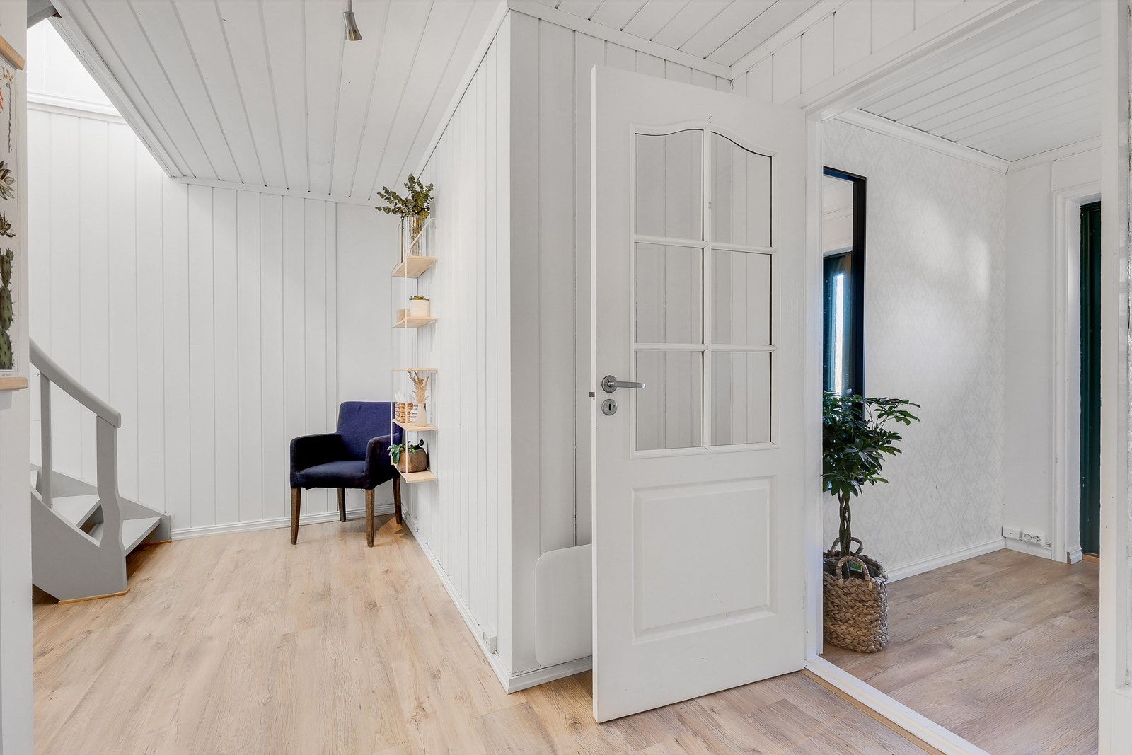 Gangen fører rett inn i hallen med svingtrapp opp til stua og hovedetasjen. Galleribilde