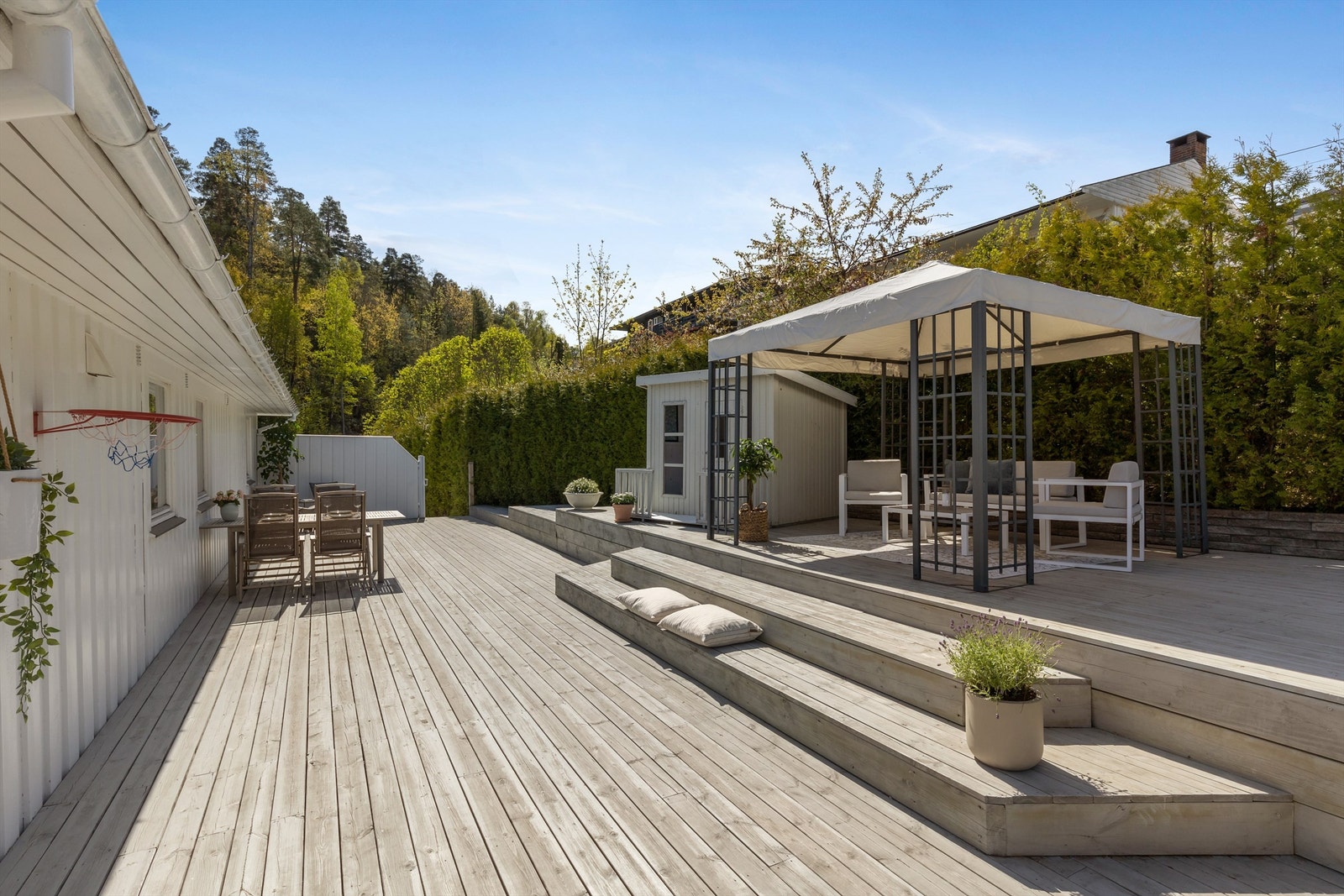 Hovedterrassen er omkranset av hekk mot nabo og har levegg mot gårdsplassen. Galleribilde