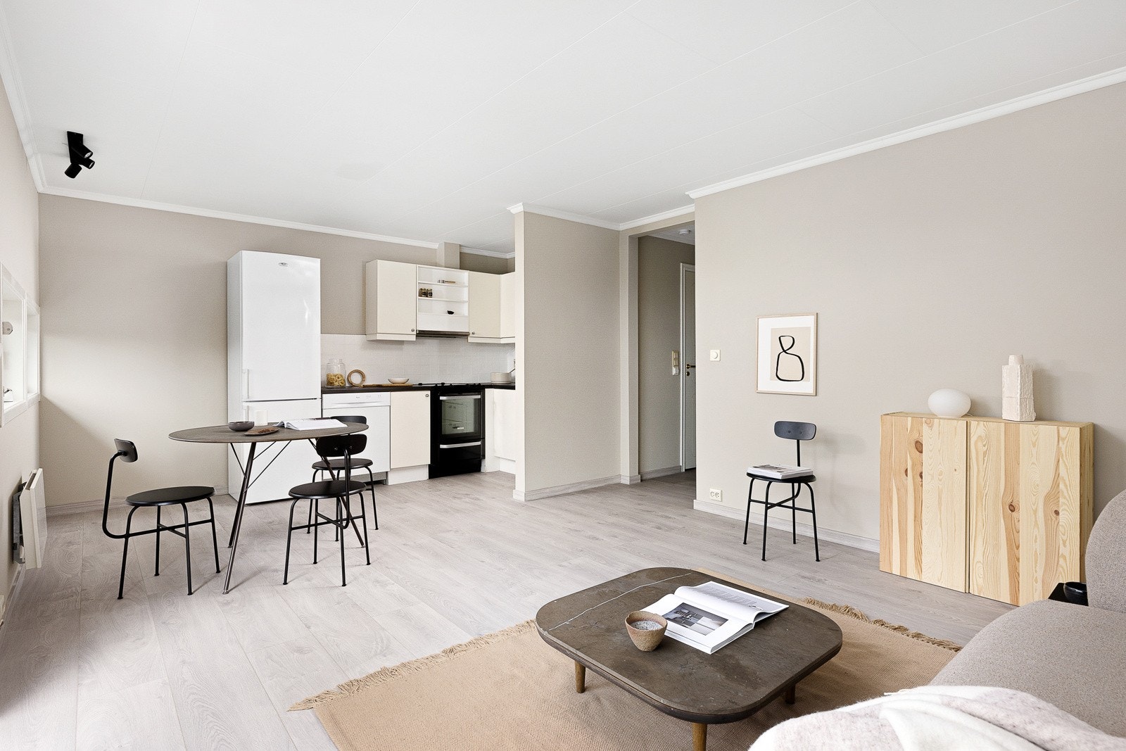 Kjøkkenet består av slette hvite fronter og overskap med belysning under. Galleribilde