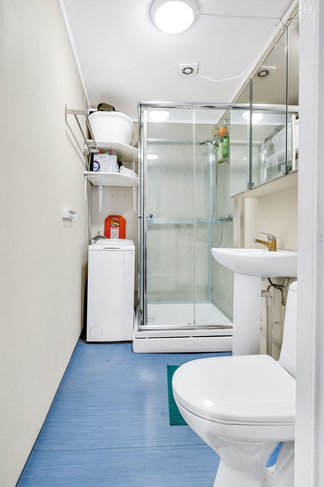 Baderom med opplegg til vaskemaskin (smal type, medfølger). Innredningen består av gulvstående toalett, servant med speilskap over og dusjkabinett. Galleribilde