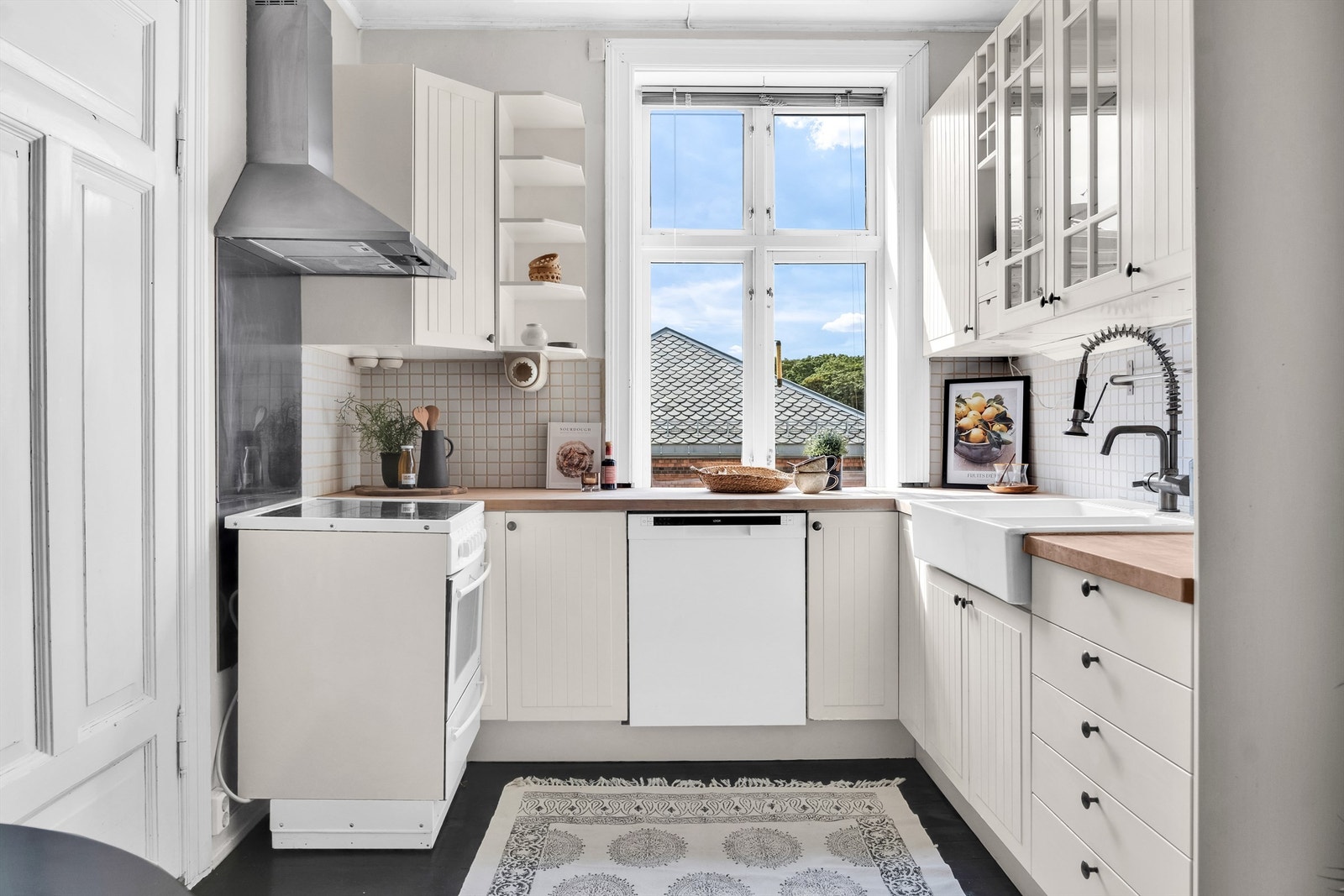 Medfølgende hvitevarer bestående av vaskemaskin og komfyr. Herlig utsyn fra kjøkkenvindu. Galleribilde