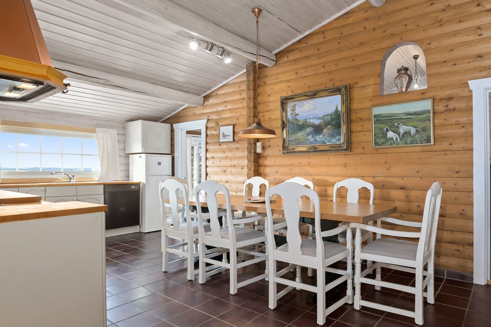 Det er god plass til mange gjester rundt spisestuen. Legg merke til utsikten fra kjøkkenvinduet. Galleribilde