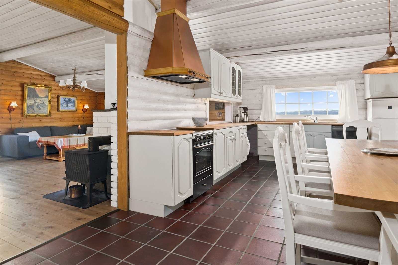 rittstående hvitevarer som stekeovn med platetopp, oppvaskmaskin og kjøl-/fryseskap. Mekanisk avtrekk med kobberhette over platetoppen. Galleribilde