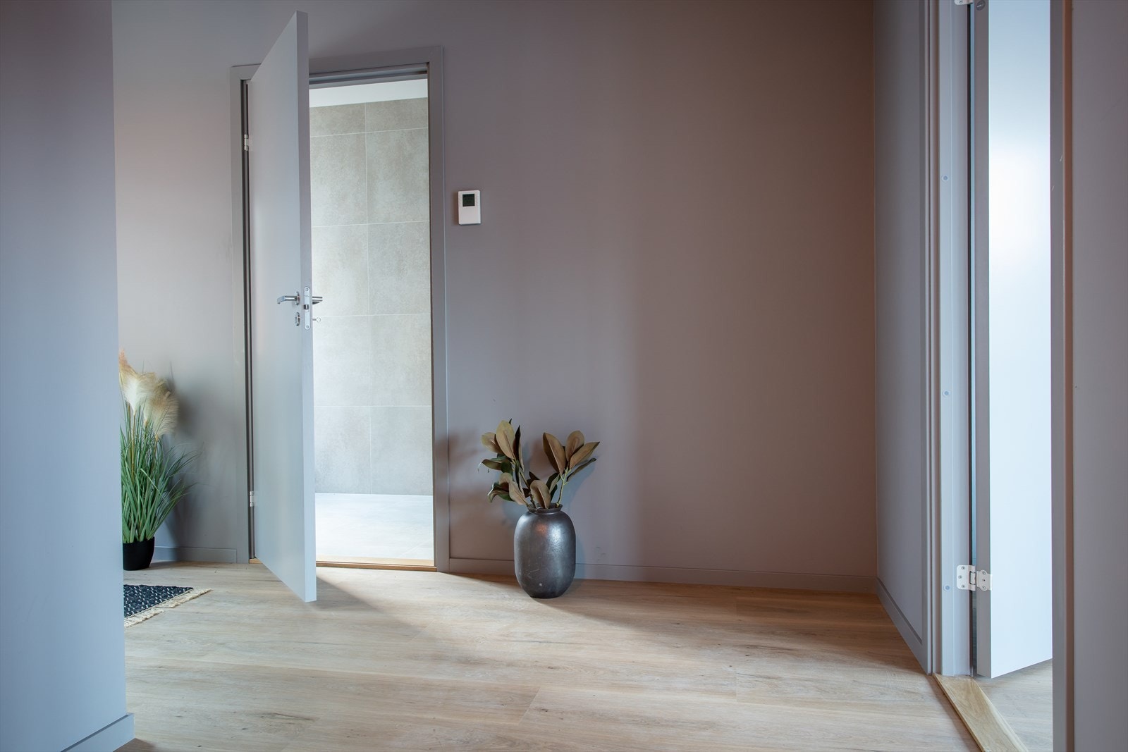 Man ønskes velkommen inn i leiligheten i en romslig entre med plass til oppheng for ytterklær og kommode- eller garderobeløsning. Galleribilde