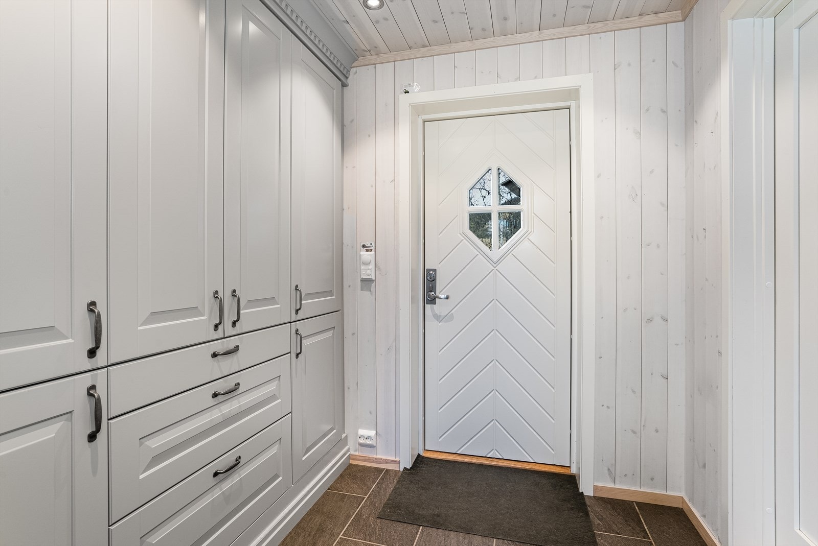 Velkommen inn! Entré med flislagt gulv med varme, og plassbygd garderobeskap fra Sigdal med godt med oppbevaring. Galleribilde