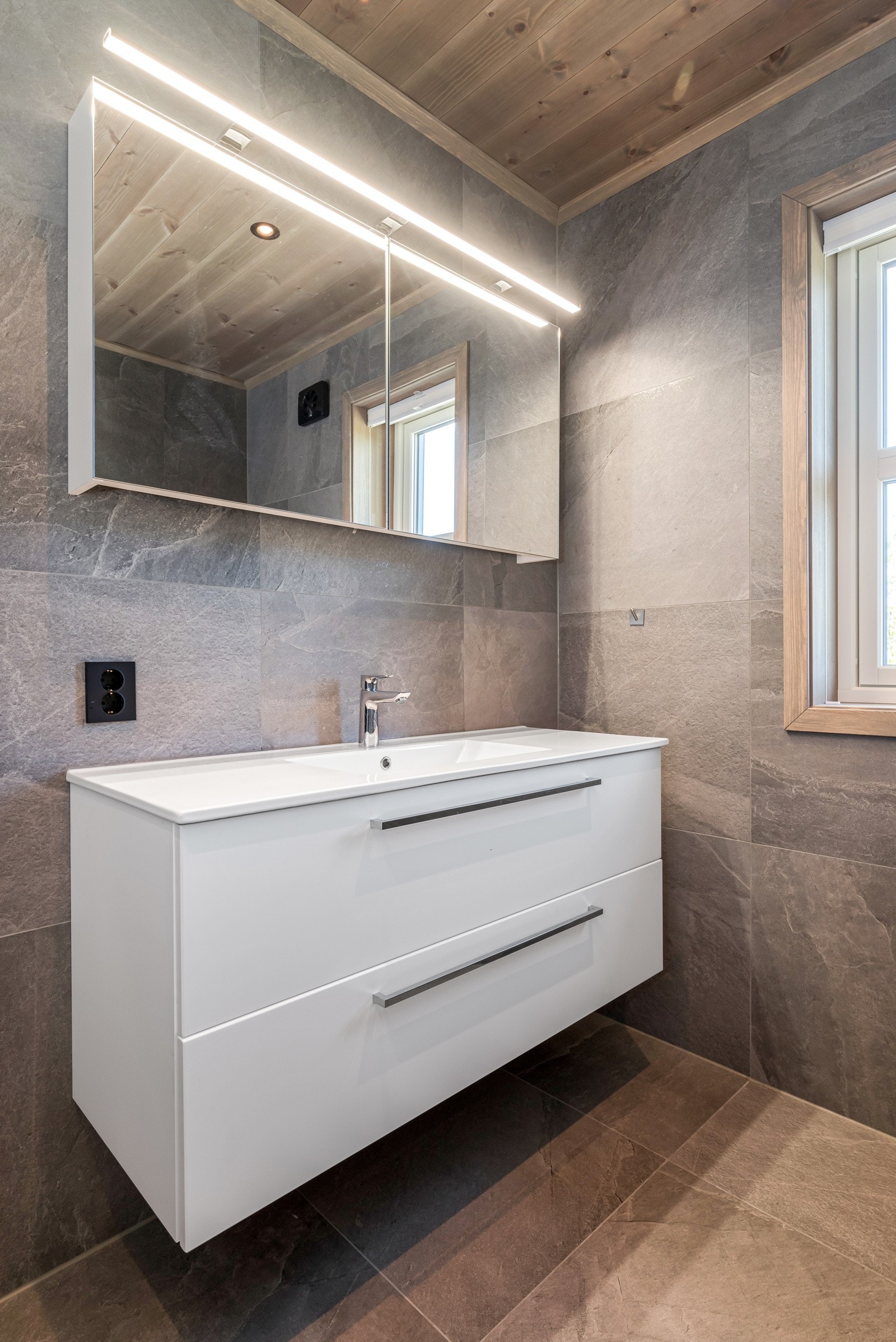 Badet har både naturlig lys, downlights i taket og speilbelysning. Galleribilde