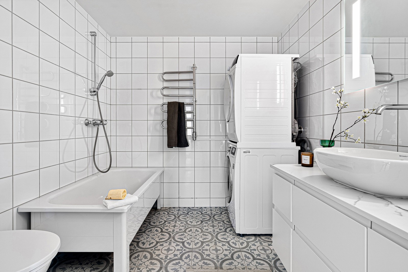 Videre er badet innredet med badekar, ny vaskemaskin og tørketrommel