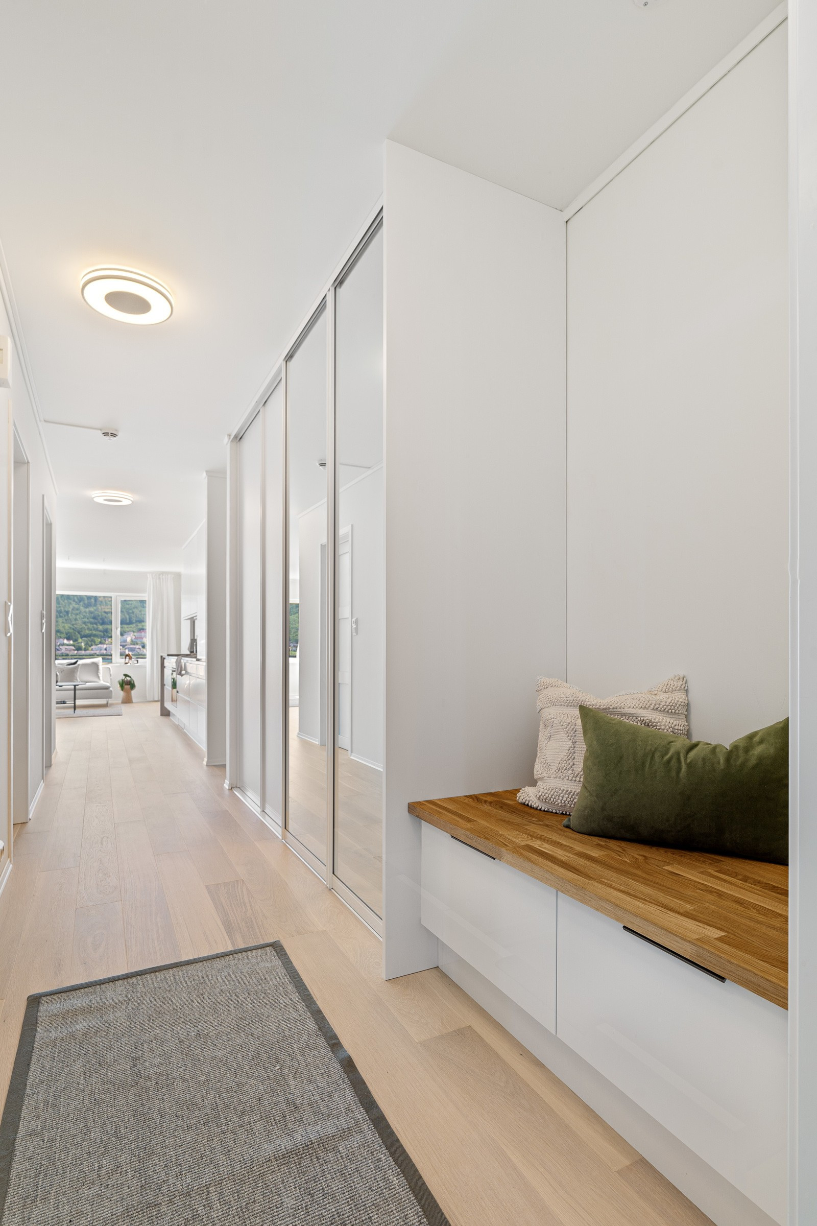 Rikelig med lagringsplass i skyvedørsgarderobe med spesialtbestilt gulv til tak speil og under sittebenk