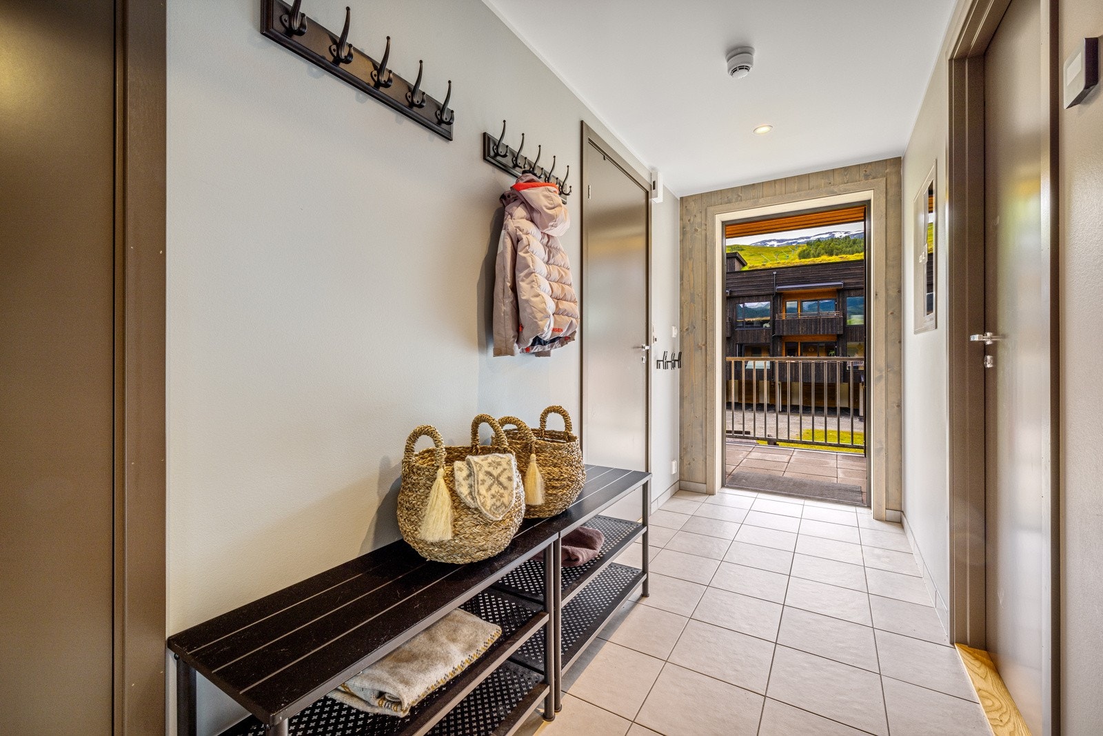 Entré med fliser på gulv og god plass til klesoppheng Galleribilde