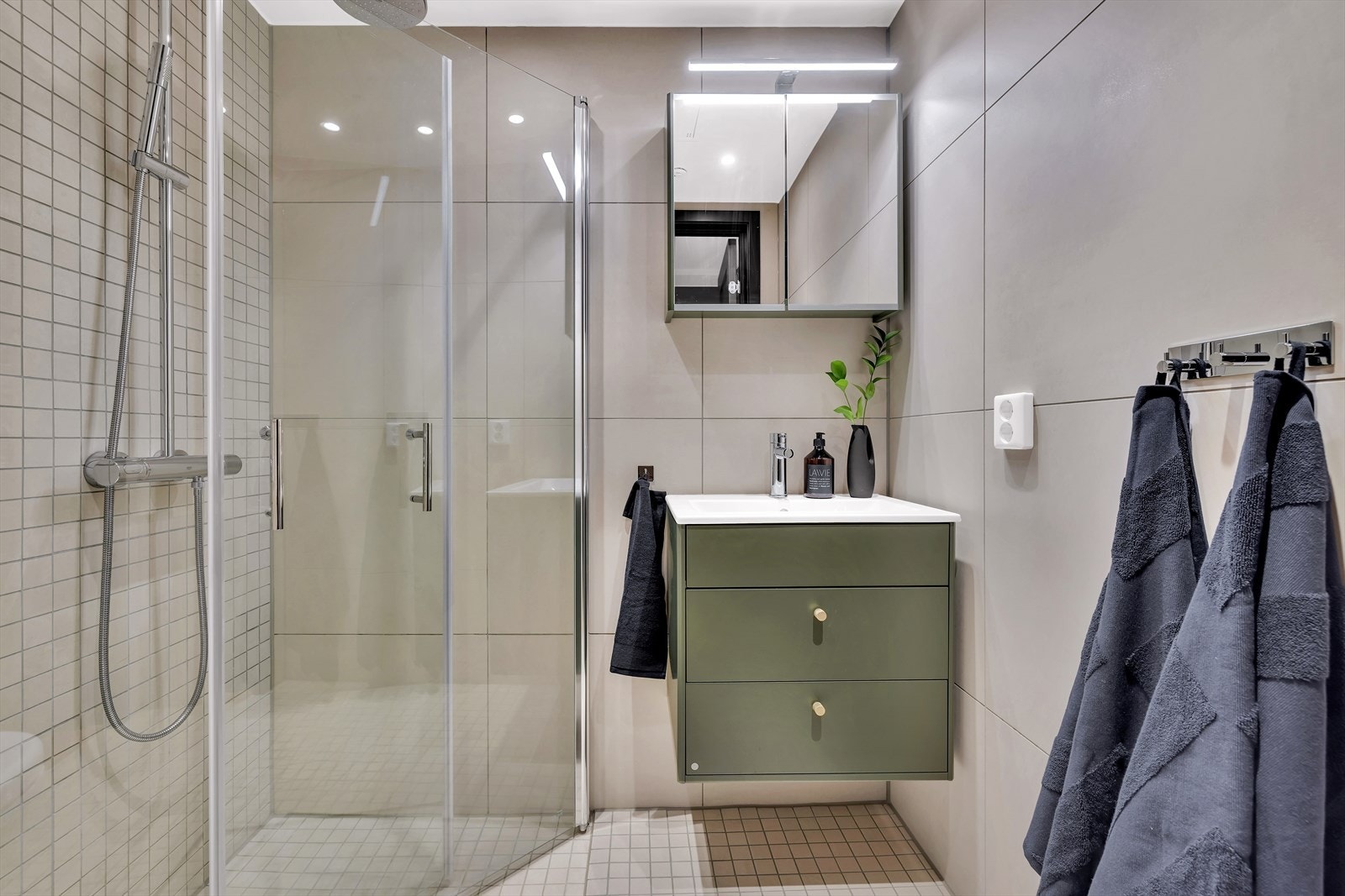 Baderom i tilknytning til hovedsoverom - Badet har delikate, beige fliser på veggene, og mosaikkfliser på gulvet. Galleribilde