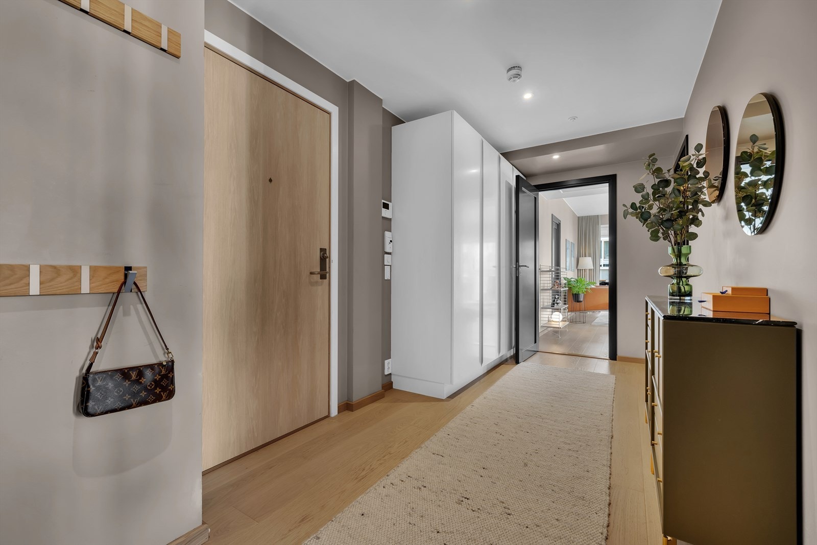 Entréen gir et godt førsteinntrykk av den delikate leiligheten. Her er det brukt moderne fargevalg på vegger som står i stil til resten av leiligheten nog det er listfrie overganger til hvitmalt himling. Galleribilde