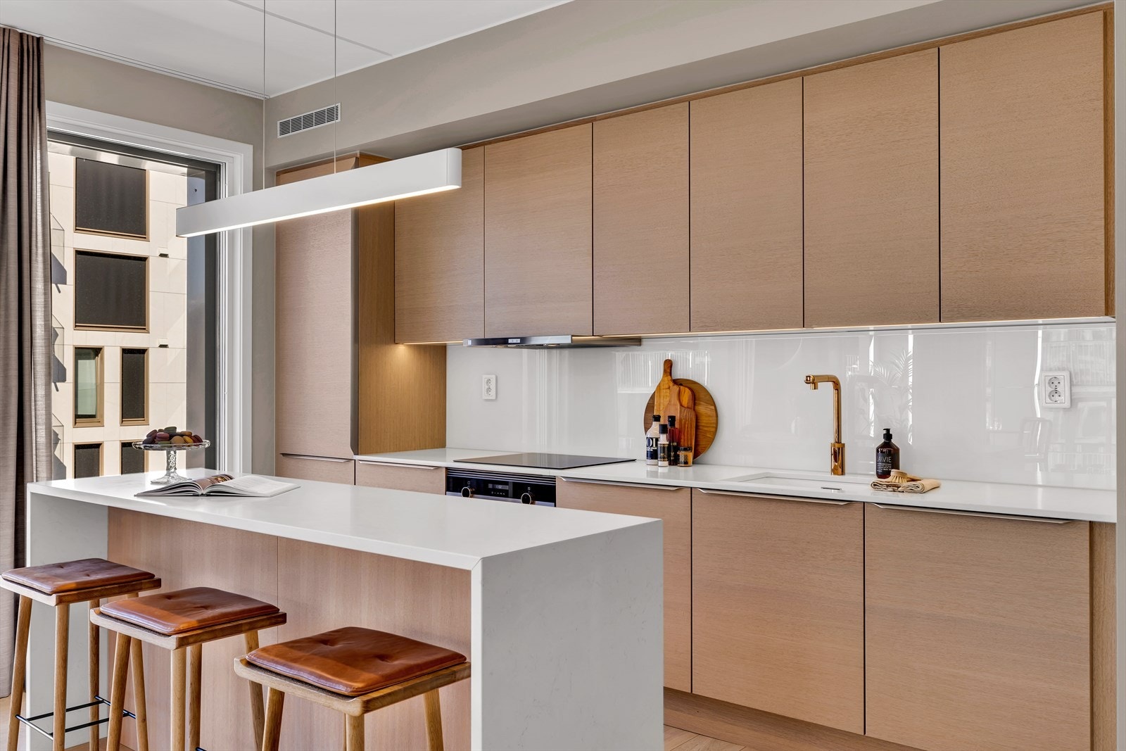 Kjøkkenet har finerte fronter av lys finer og en lys støpt benkeplate med nedfelt vaskekum. Galleribilde