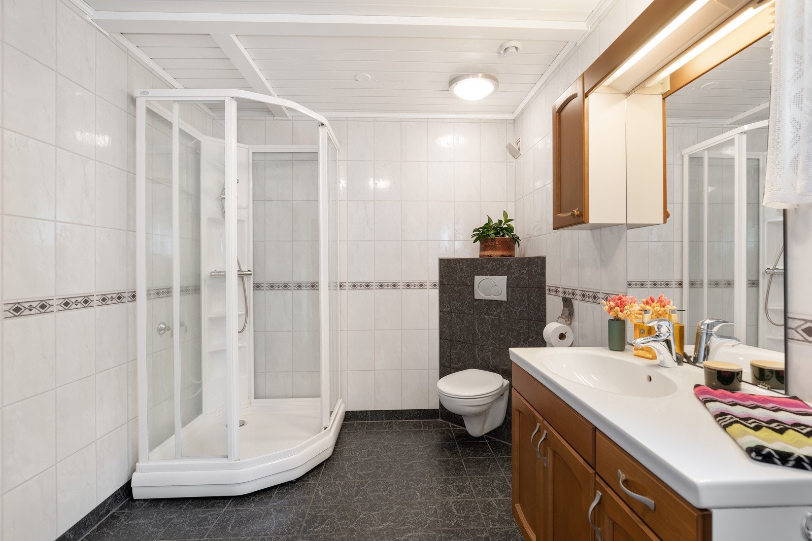 For øvrig har badet veggmontert toalett, dusjkabinett, skyllekum i stål og opplegg for vaskemaskin. Galleribilde