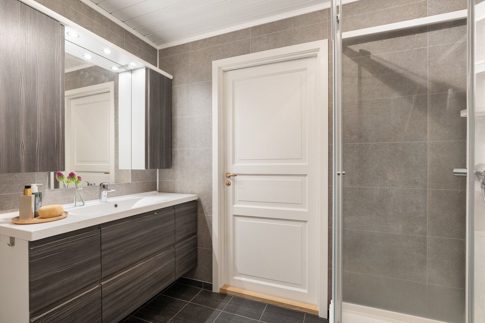 Videre har badet veggmontert toalett, dusjkabinett og badekar. Galleribilde