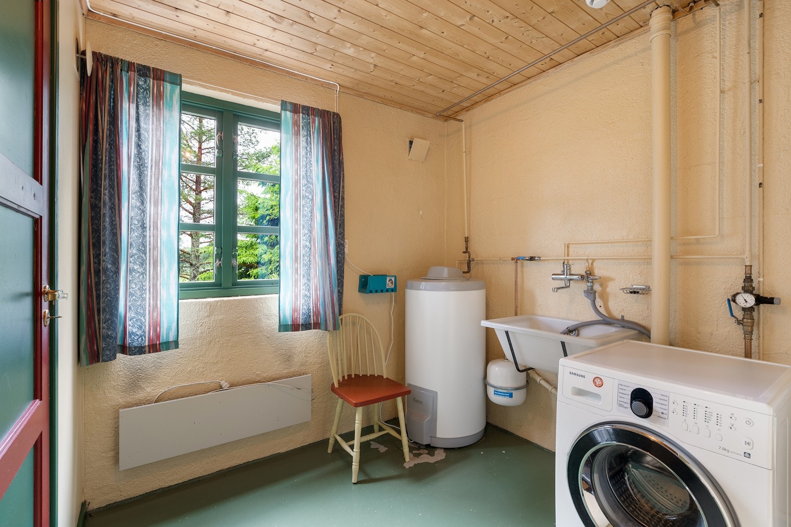 Vaskerommet ligger i underetasjen og er utstyrt med veggmontert skyllekum i plast og opplegg for vaskemaskin. Galleribilde