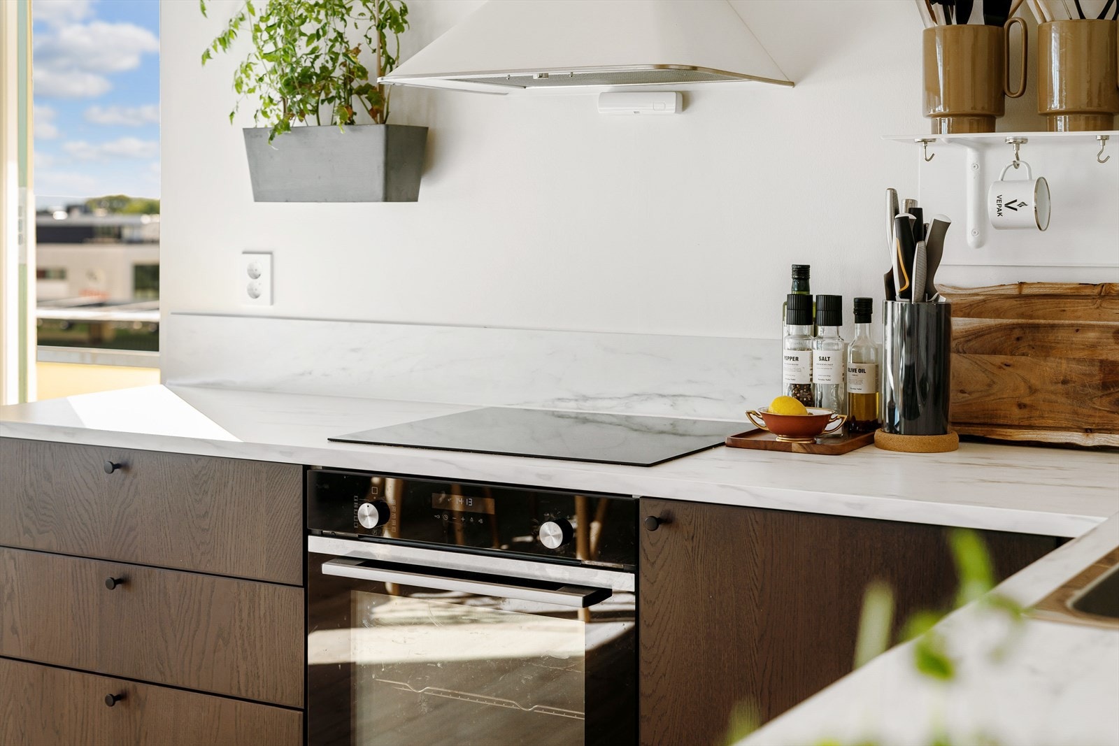 Integrerte hvitevarer bestående av stekeovn, platetopp, oppvaskmaskin og kullfiltervifte Galleribilde