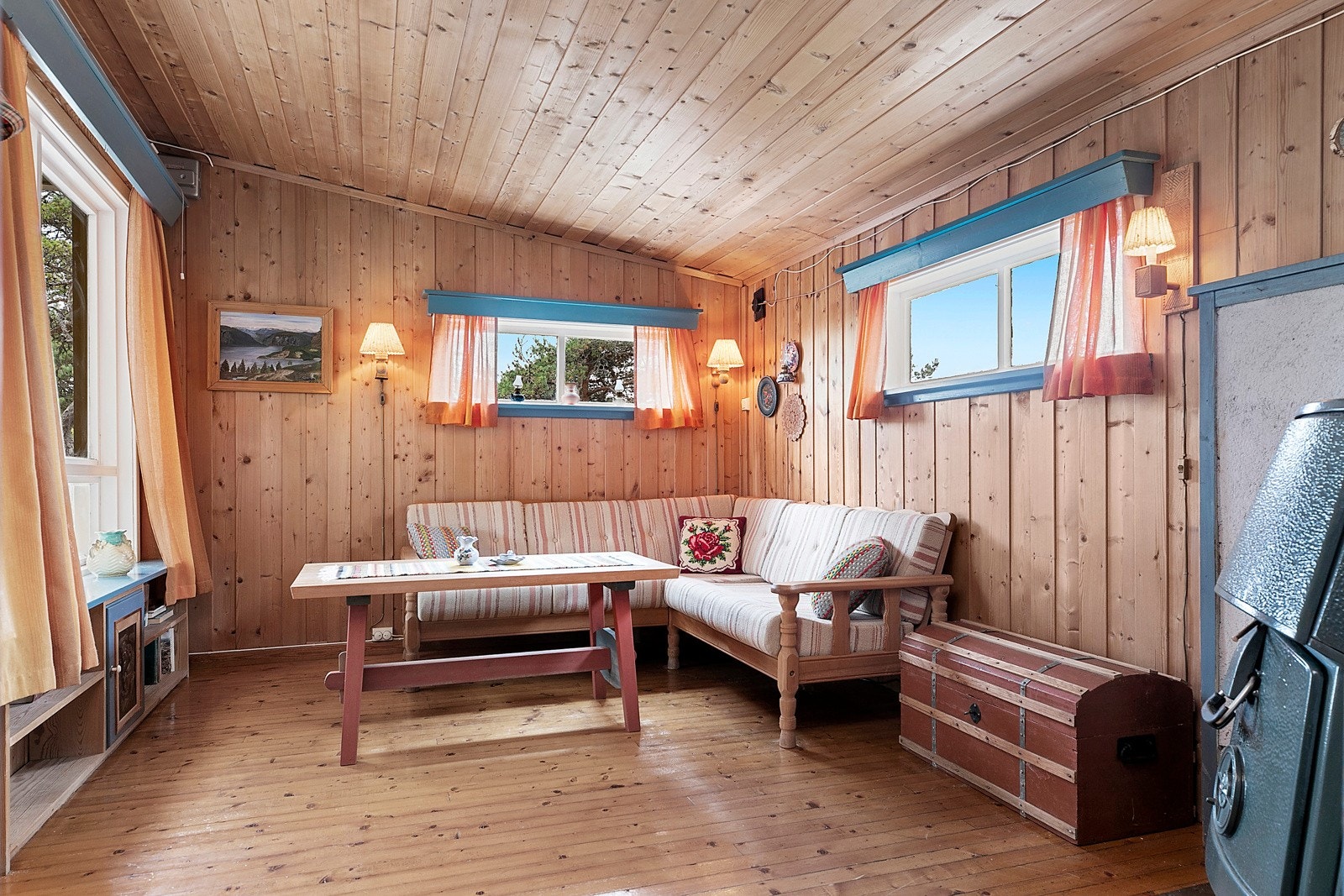 Stue med flere vinduer som slipper naturen inn Galleribilde