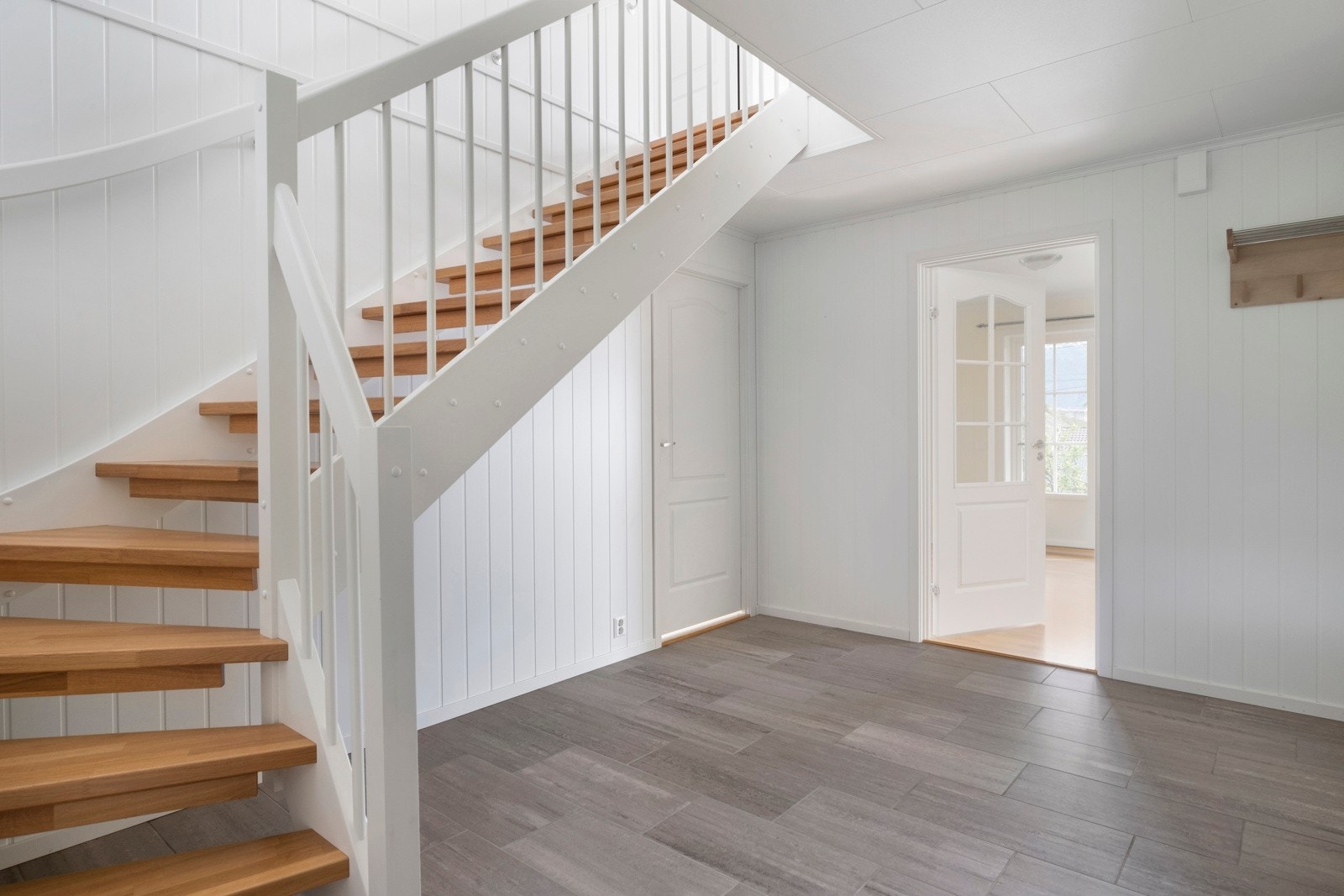 Velkommen inn! Romsleg hall med fliser på golv. Dør vidare til henhaldsvis kjøken og stove. Galleribilde