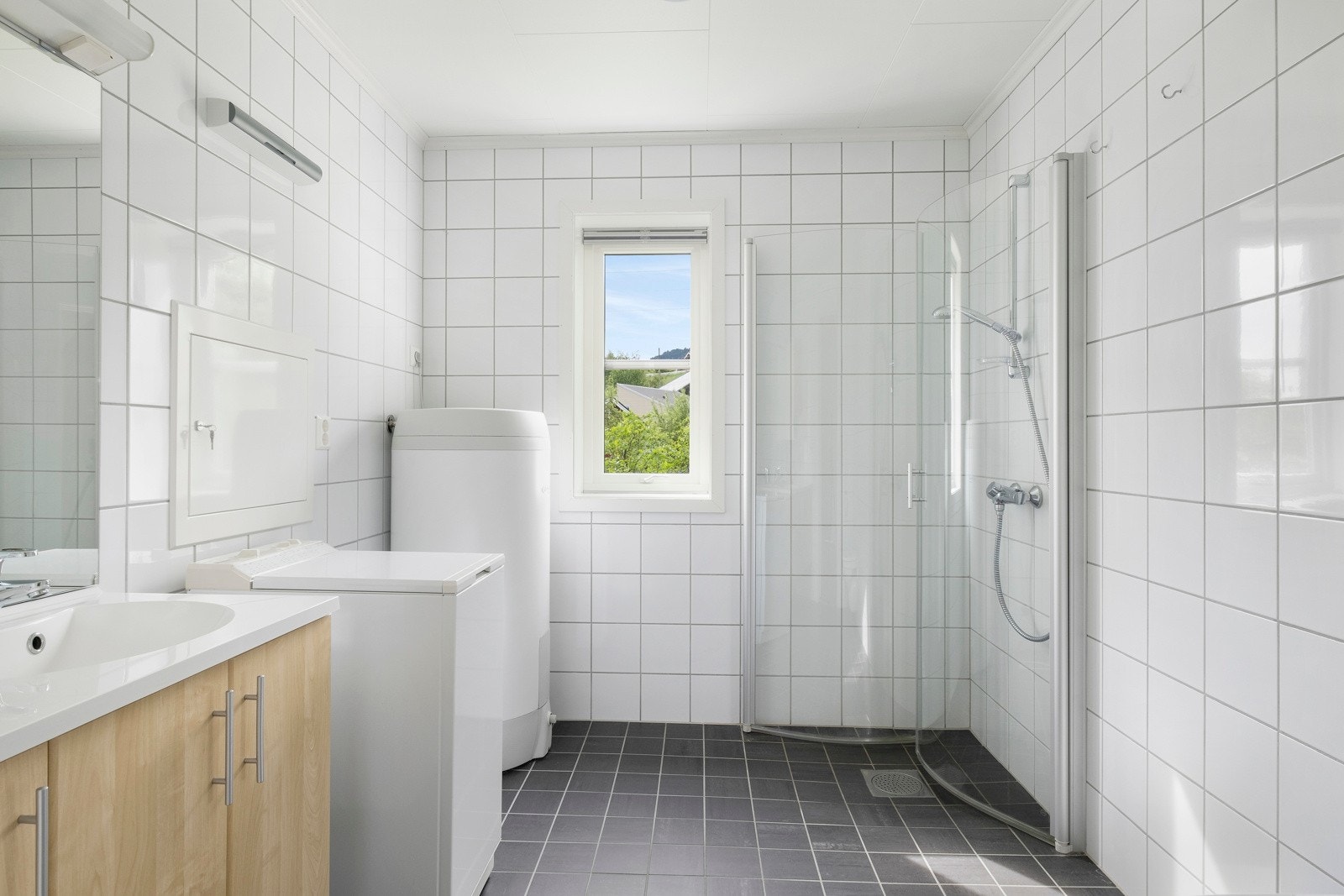 Lyst og fint heilflisa bad i etasjen, som òg fungerer som delt vaskerom. Galleribilde