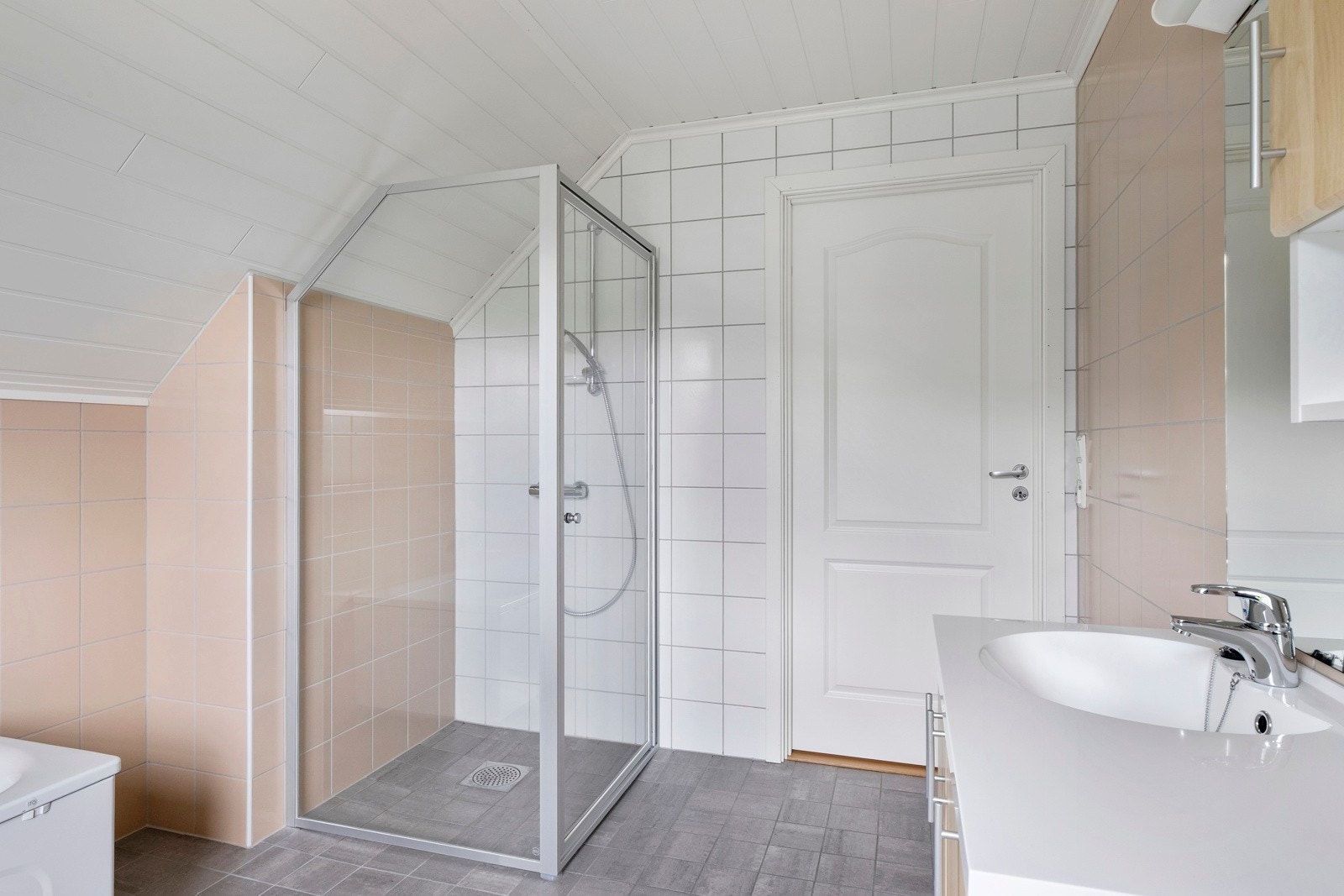 Badet er innreia med servant med lys skåpseksjon, veggmontert toalett, badekar og dusjhørne. Galleribilde