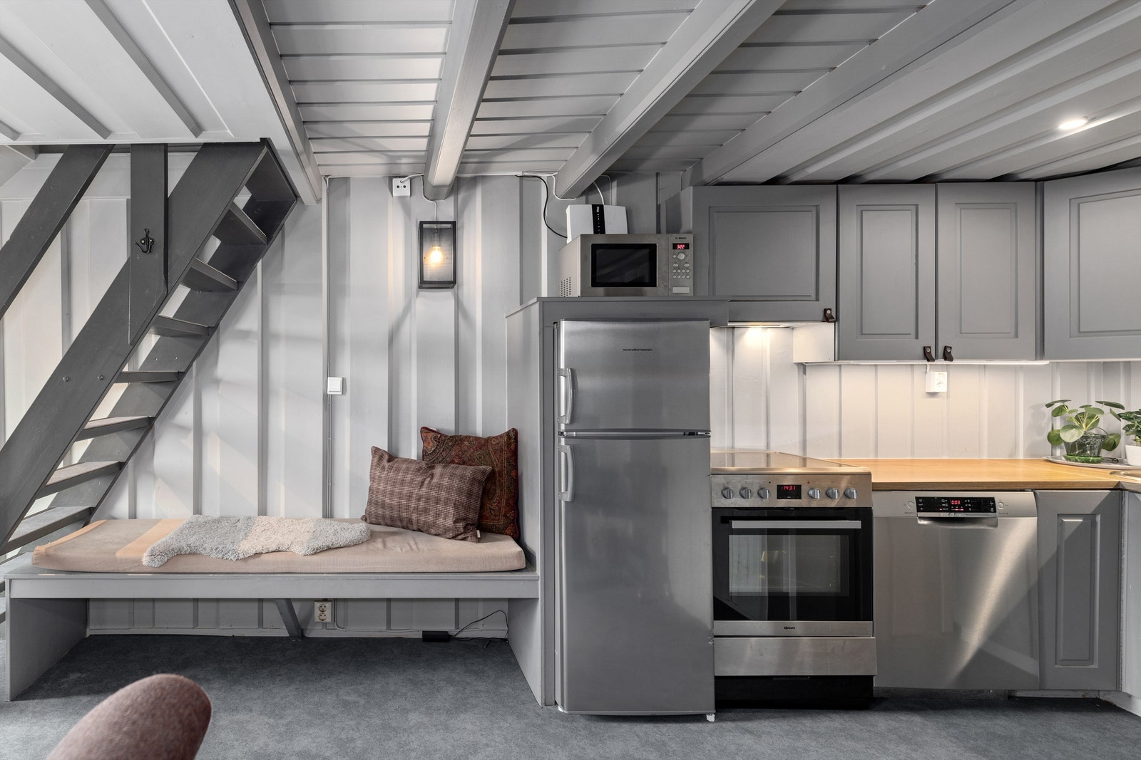 Koselig allrom med malte overflater og adkomst til bad og badstue på samme plan. Trapp opp til andre etasje Galleribilde