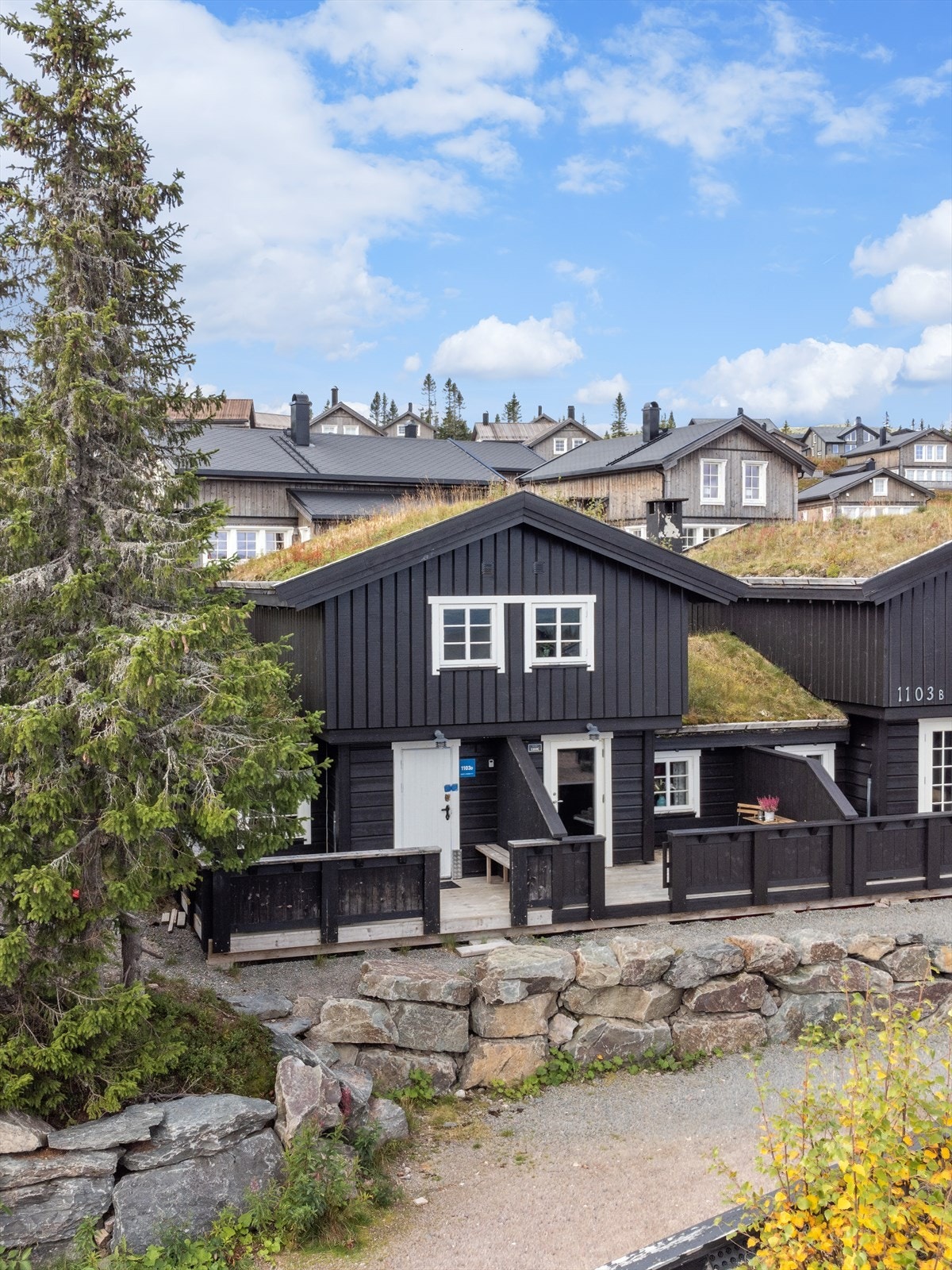 Fint opparbeidet utendørs med forstøtningsmur i naturstein mot hytta Galleribilde