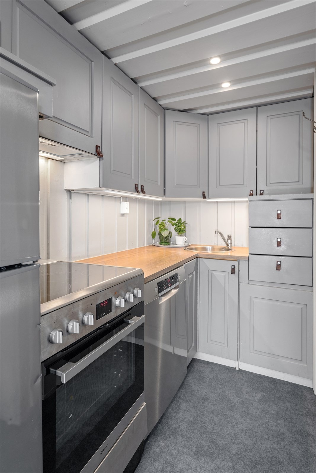 Innredning med profilerte heltre dører og skuffer. Kjøl/fryseskap, komfyr og vaskemaskin i åpen løsning Galleribilde