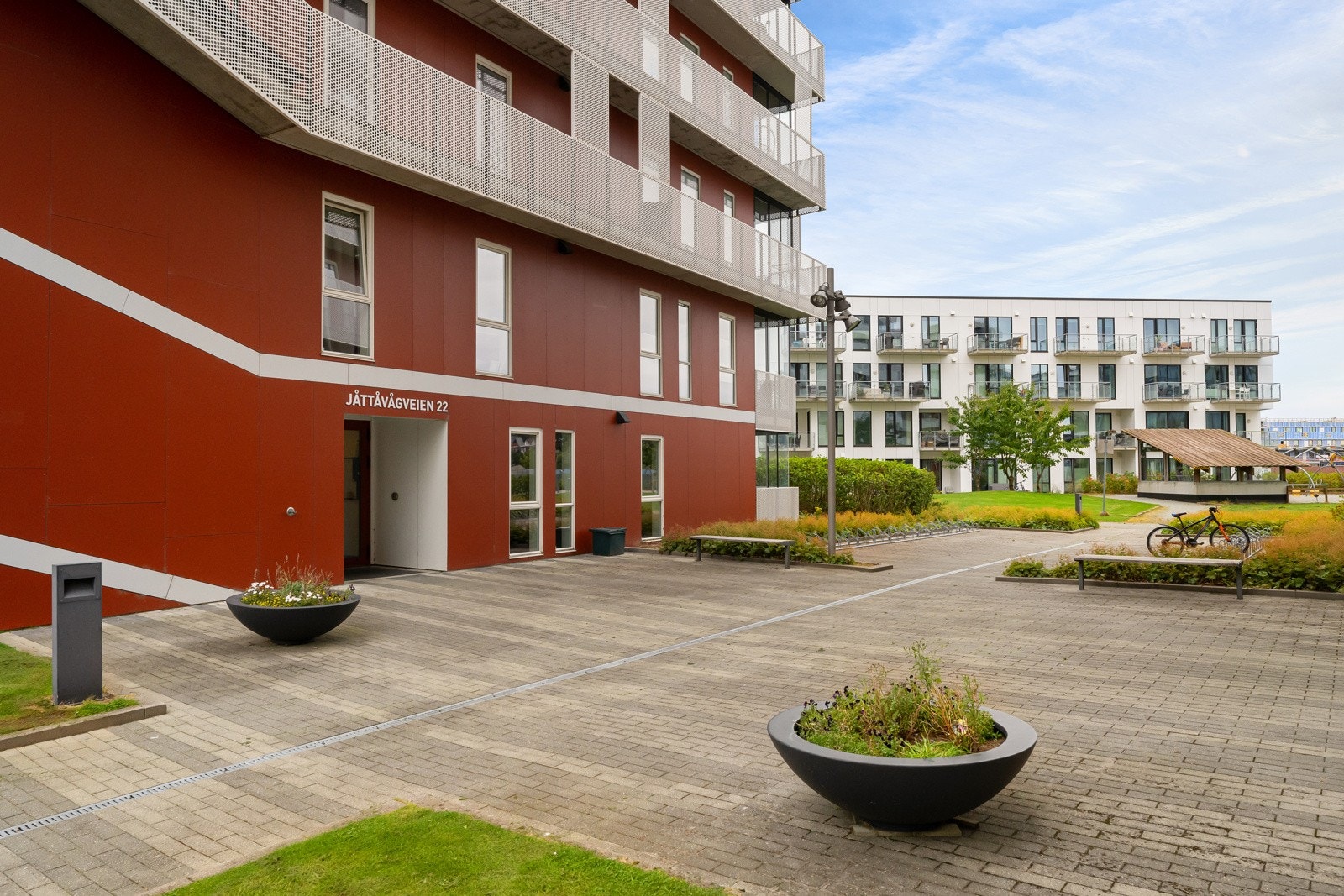 Felles tomteområde er pent opparbeidet med steinlagte internveier, gressplen, beplantning og parkeringsområder. Galleribilde