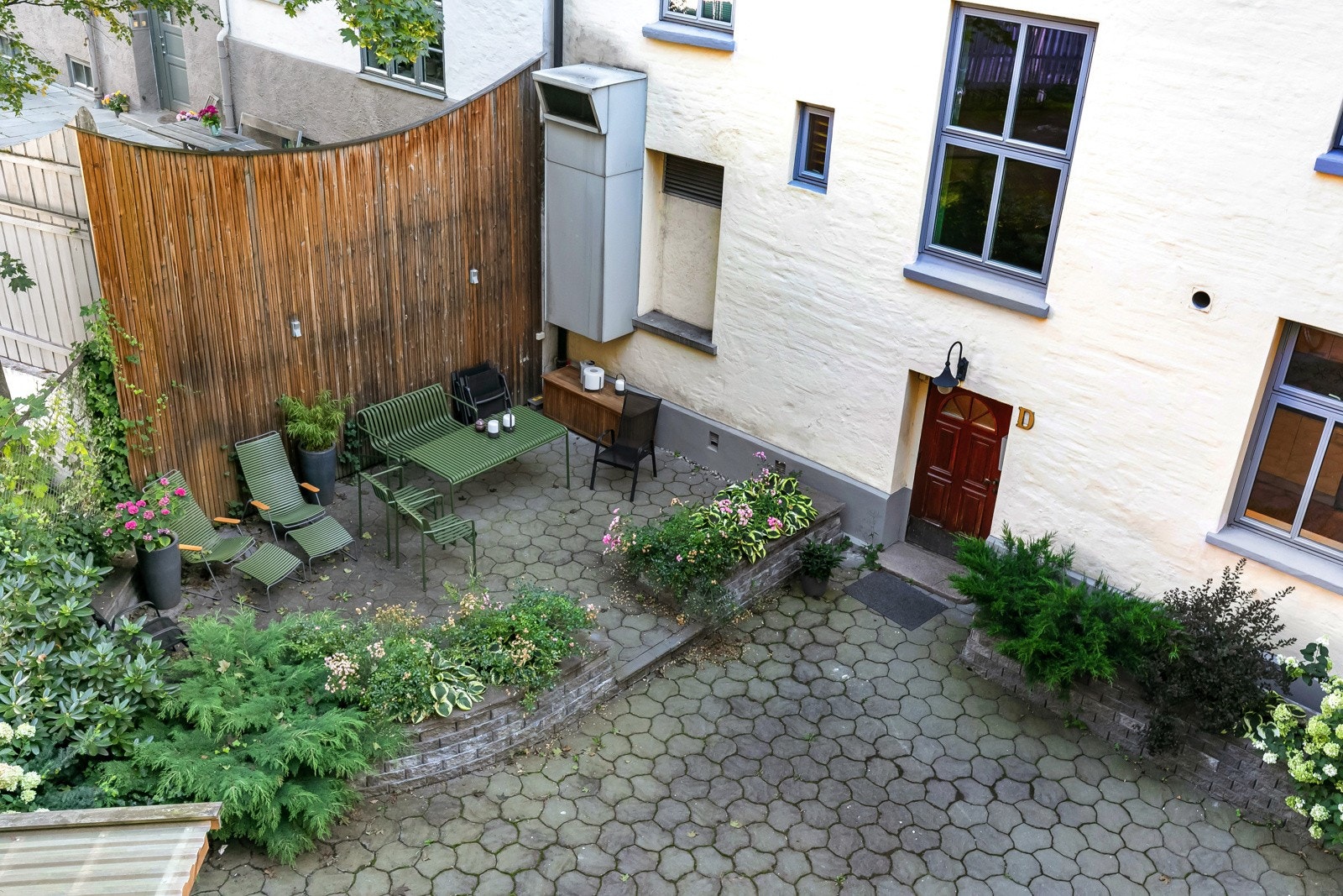 Pent beplantet og steinlagt gårdsrom som ble oppgradert i 2015 med hyggelig grillplass, flott belysning og sittegrupper som kan benyttes fritt av beboerne. Galleribilde