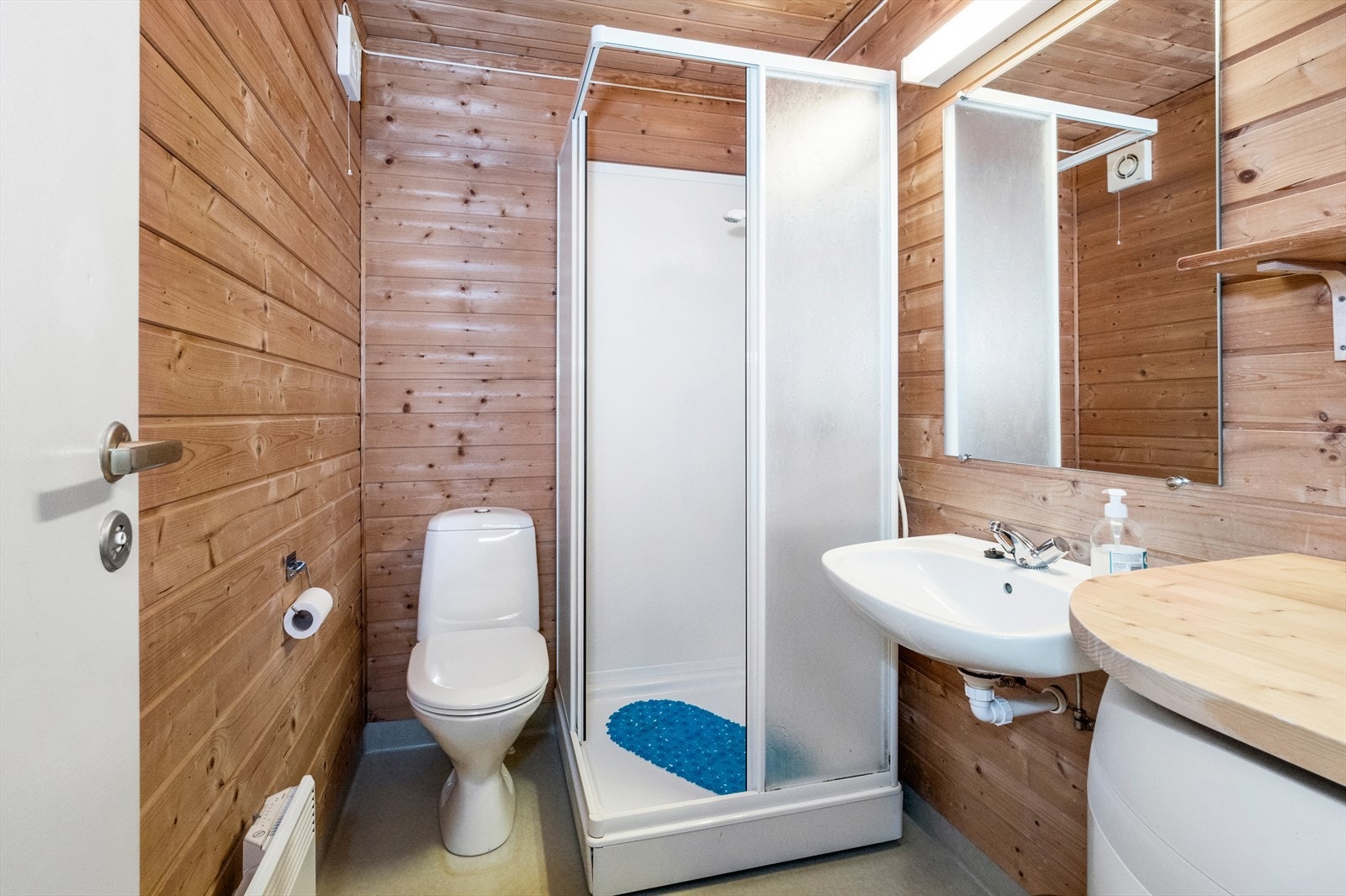 Baderom med wc, dusjkabinett og servant med innlagt offentlig vann og avløp. Galleribilde