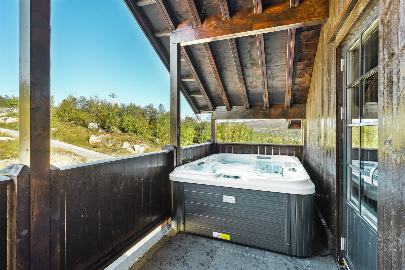 Jacuzzi på den ene balkongen med kveldsol og utsikt mot Galten og skisenteret. Galleribilde